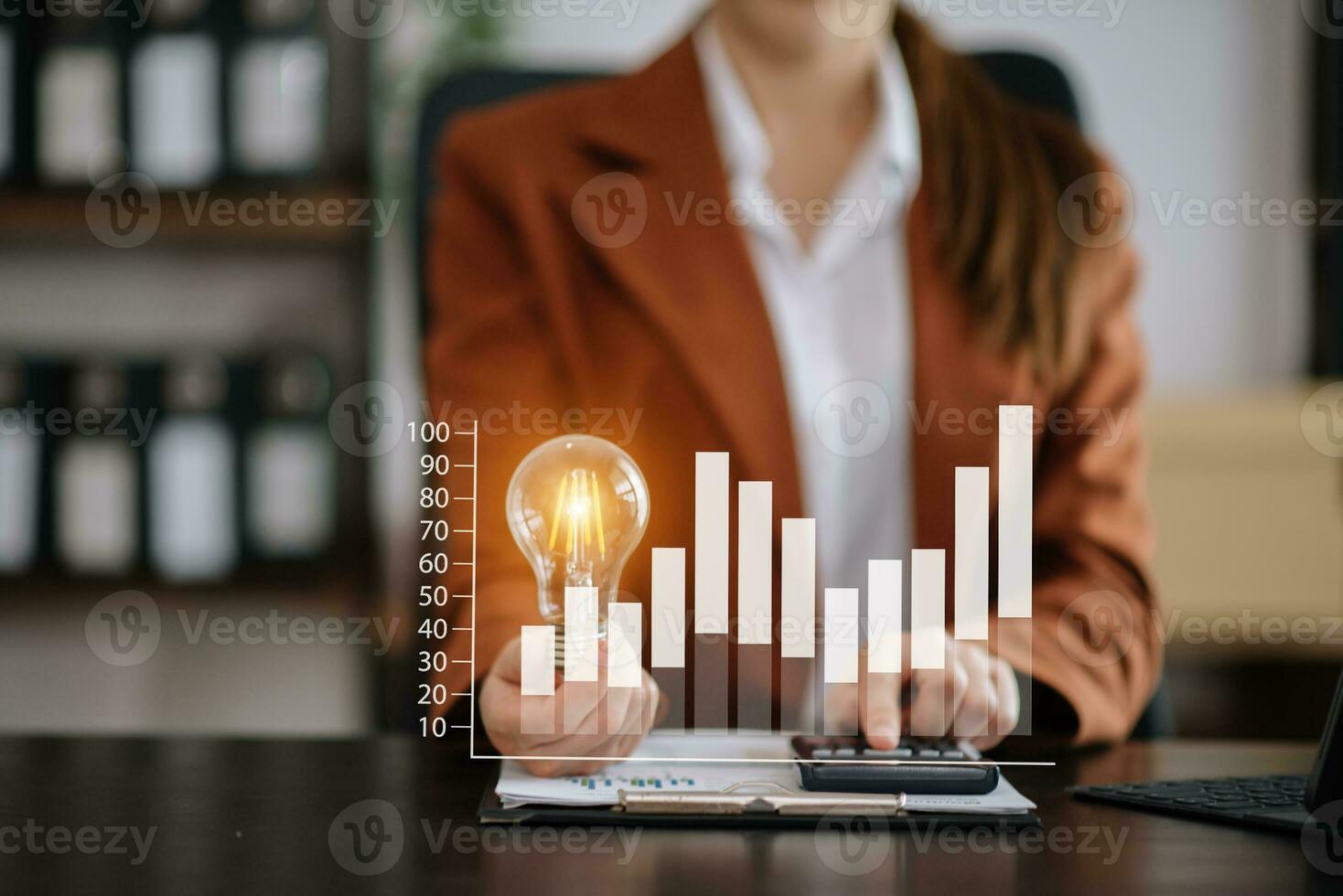 Businesswoman holding and putting lightbulb on coins stack on table for saving energy and money conceptIdea saving energy photo