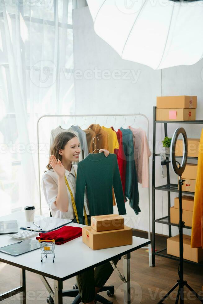 Beautiful lady blogger showing clothes in front of the camera to recording vlog video live streaming photo
