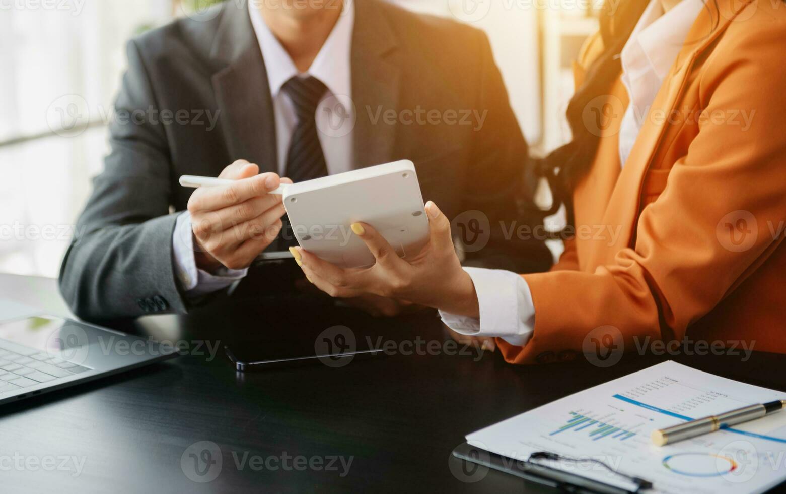 Business documents on office table with smart phone and calculator digital tablet and graph business with social network diagram and two colleagues discussing data working photo