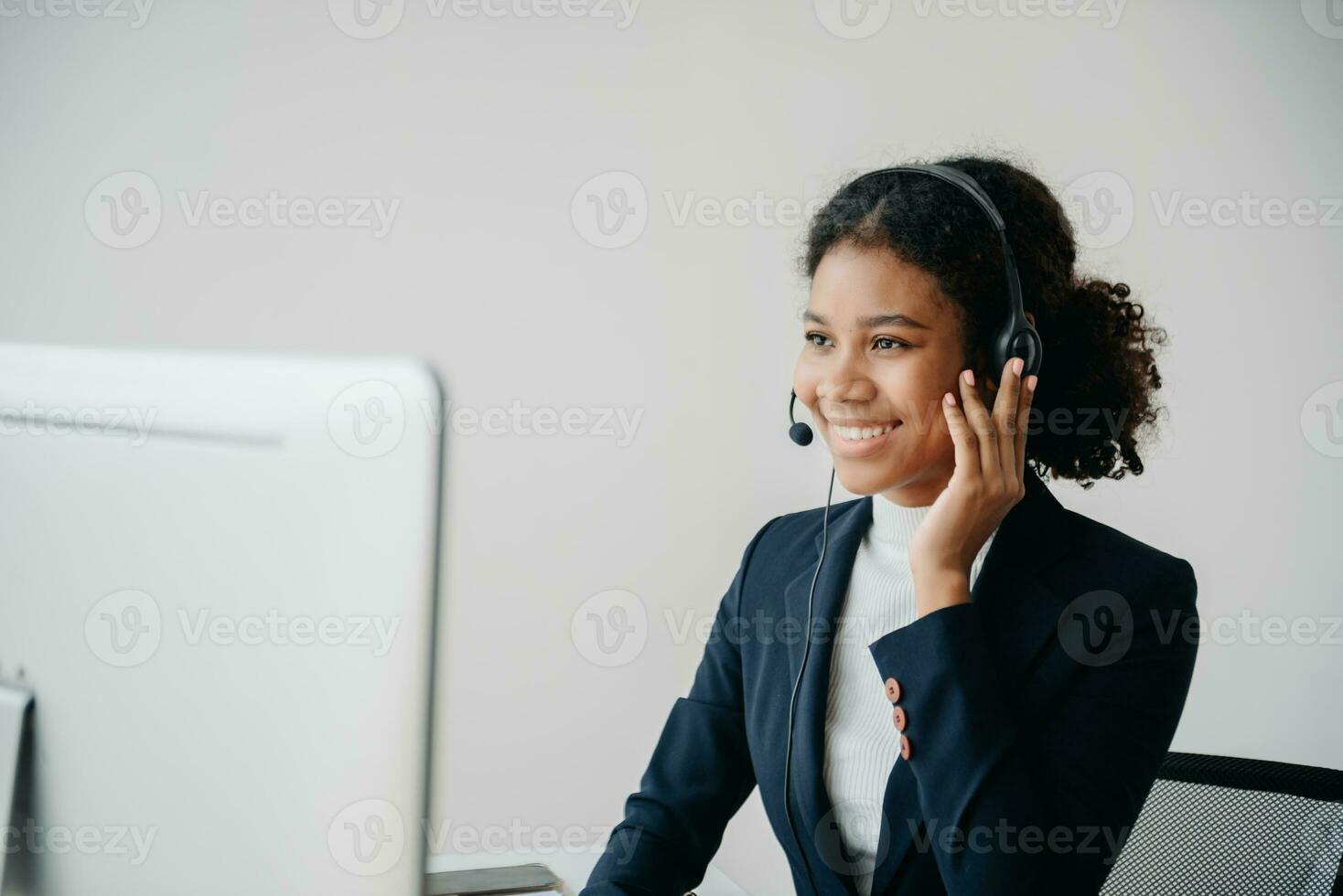 Serious call center operator in wireless headset talking with customer, woman in headphones with microphone consulting client on phone in customer support service in office photo
