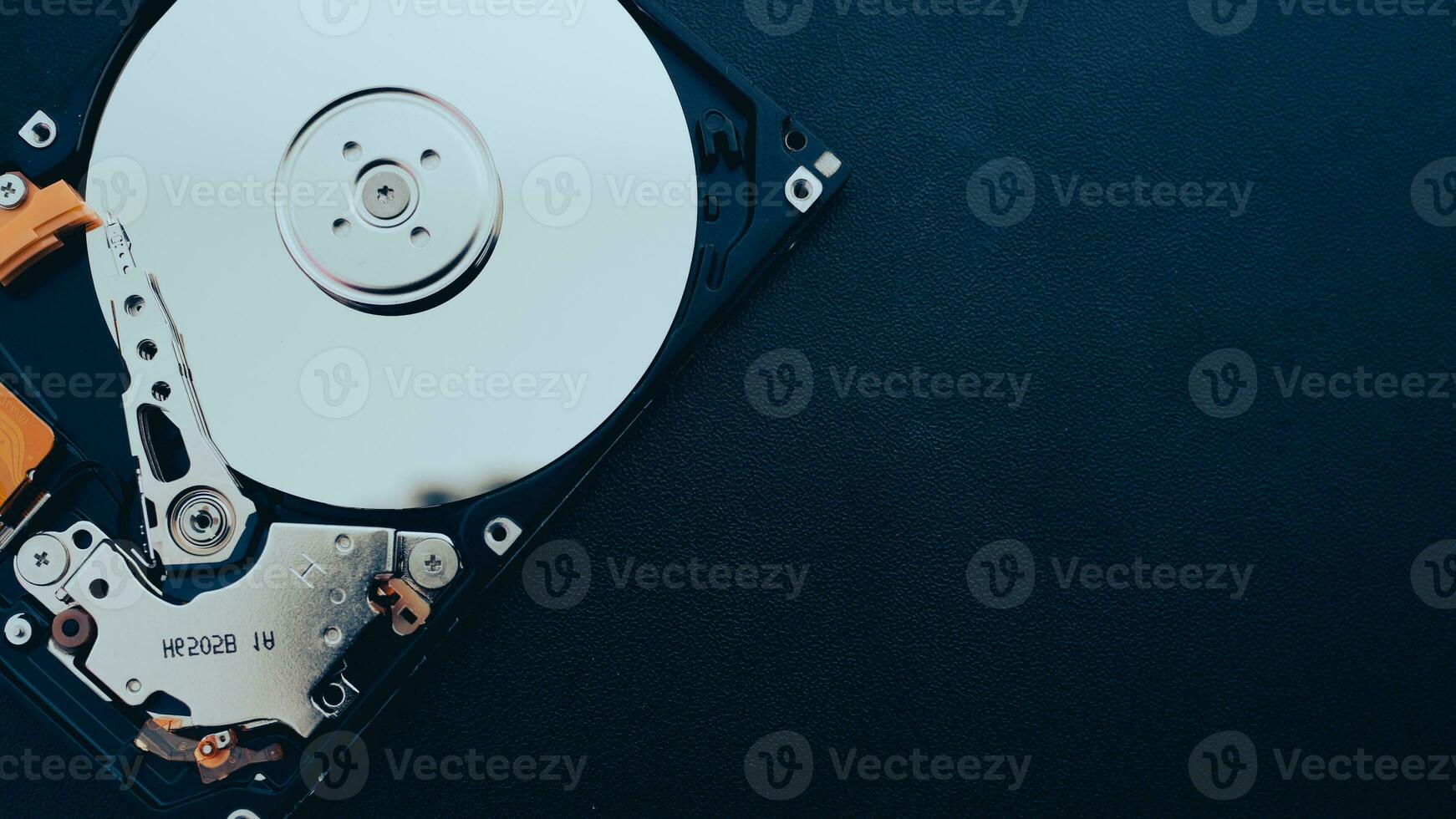 An open hard disk disassembled HDD of a computer or laptop lies on a blue surface. Computer hardware and accessories. Hard disk storage. photo
