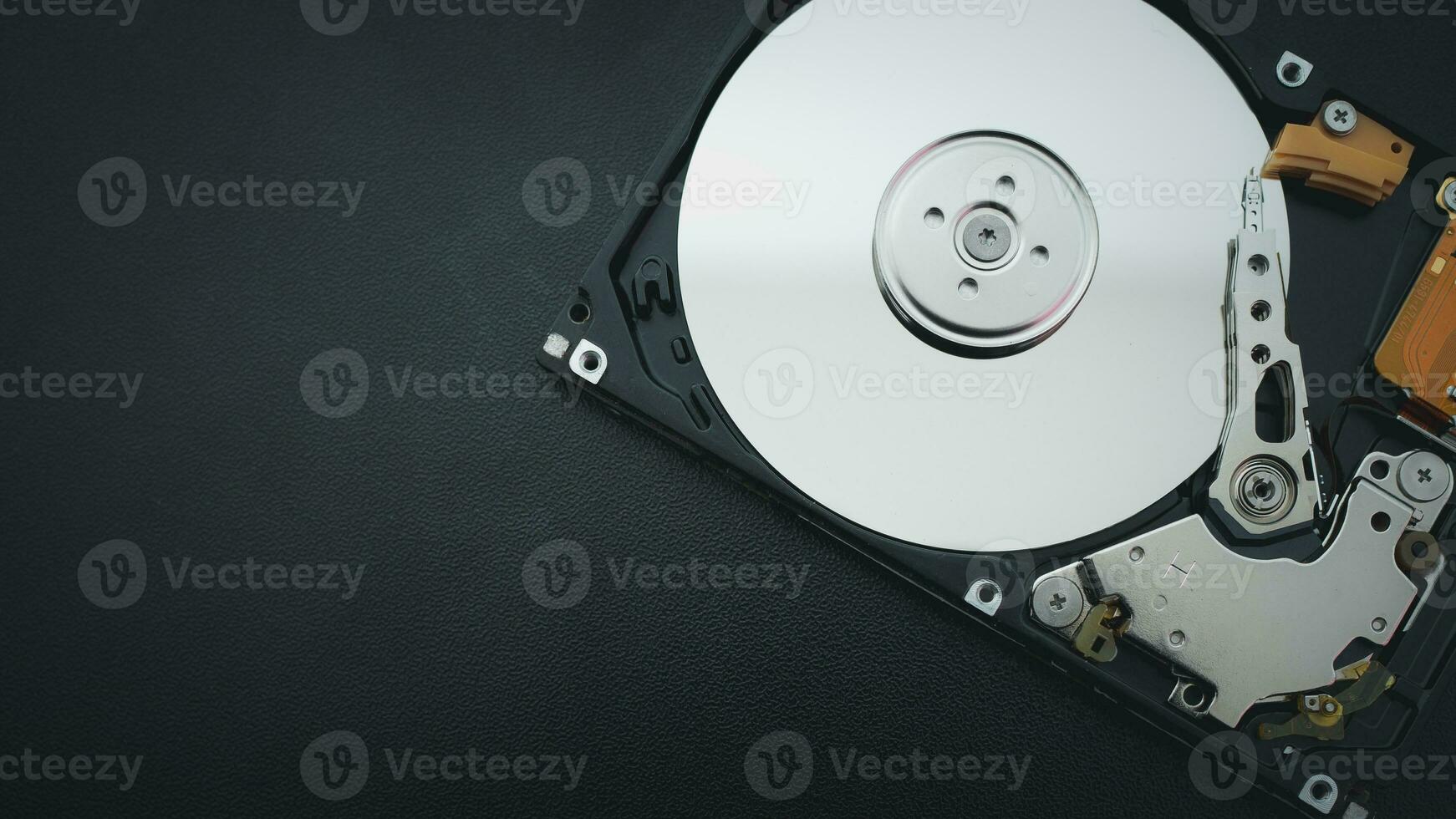 An open hard disk disassembled HDD of a computer or laptop lies on a blue surface. Computer hardware and accessories. Hard disk storage. photo