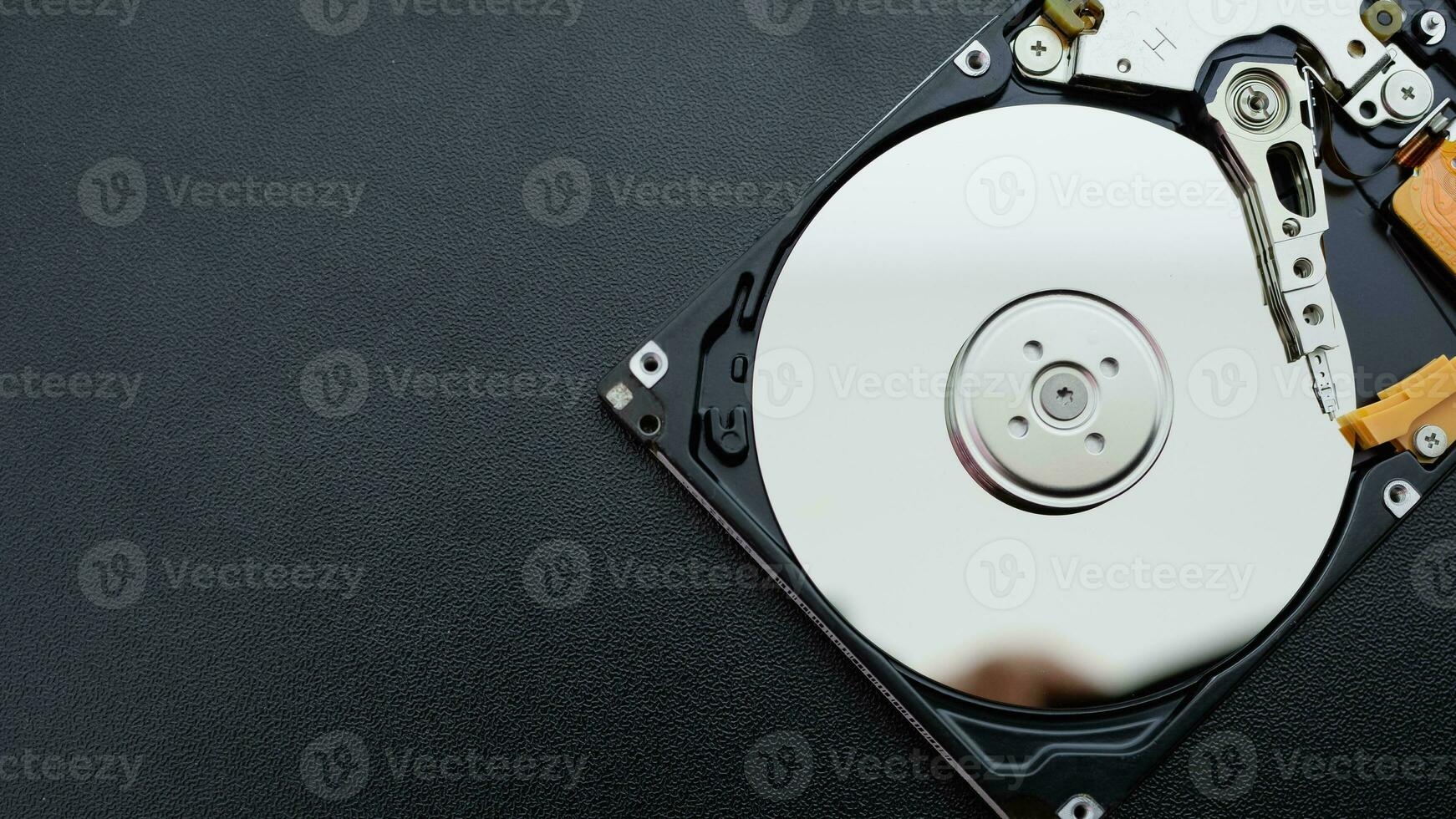 open hard disk drive HDD of computer or laptop lies on dark matte surface. photo