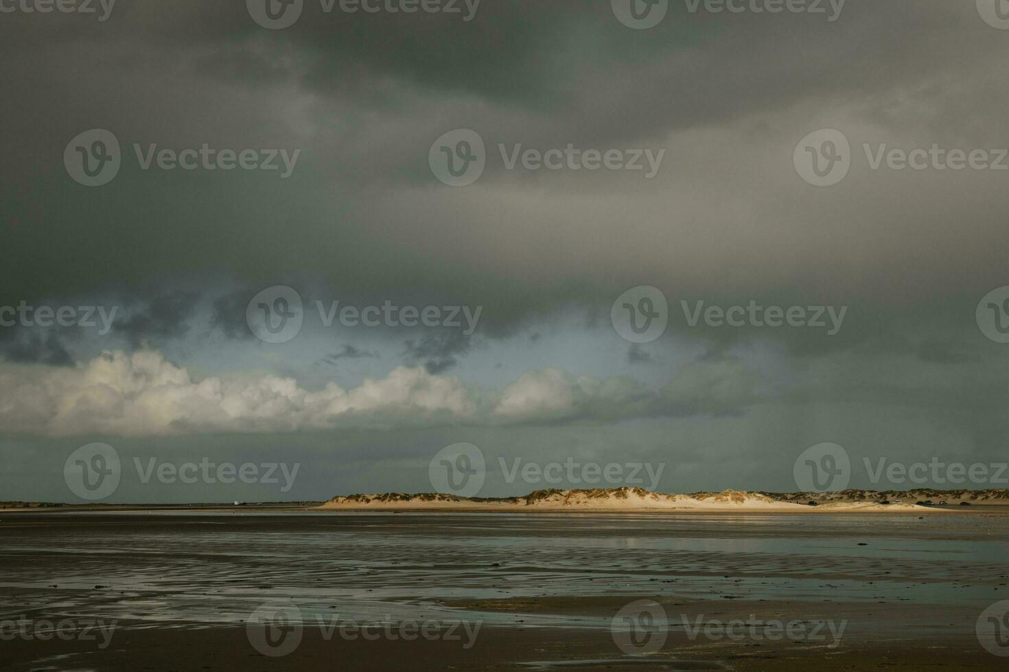 Enlightened sand dunes on horizon on the coastline of the North sea on the Denmark Romo island during the low tide photo