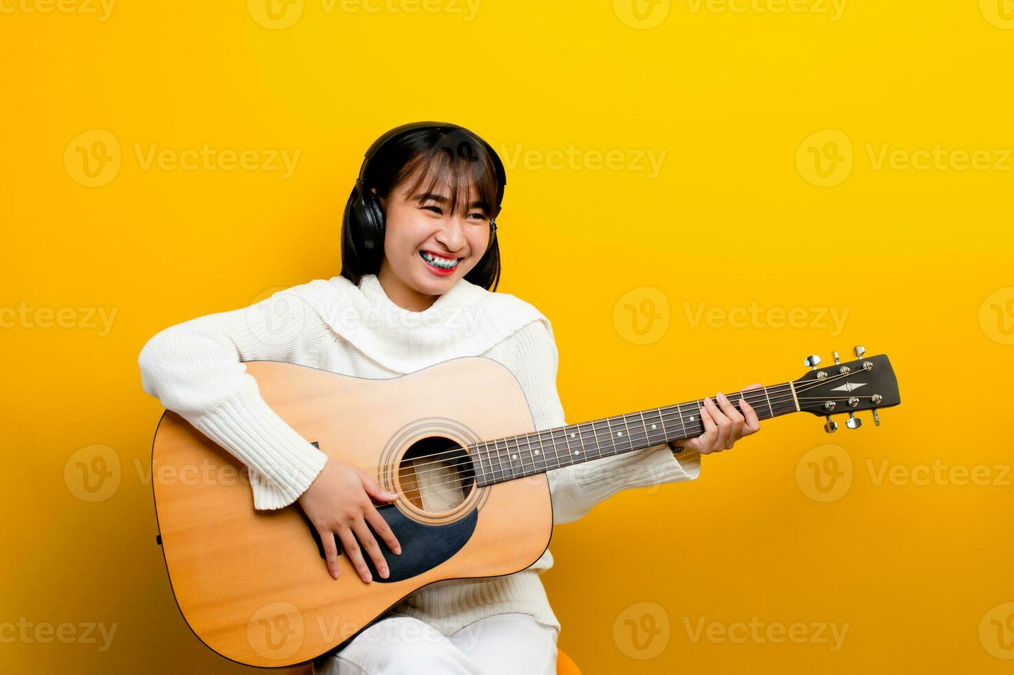 jugando guitarra y escuchando a música con auriculares disfrutar clásico música géneros disfrutar escuchando a luz, cómodo, relajante mientras escuchando a música. foto