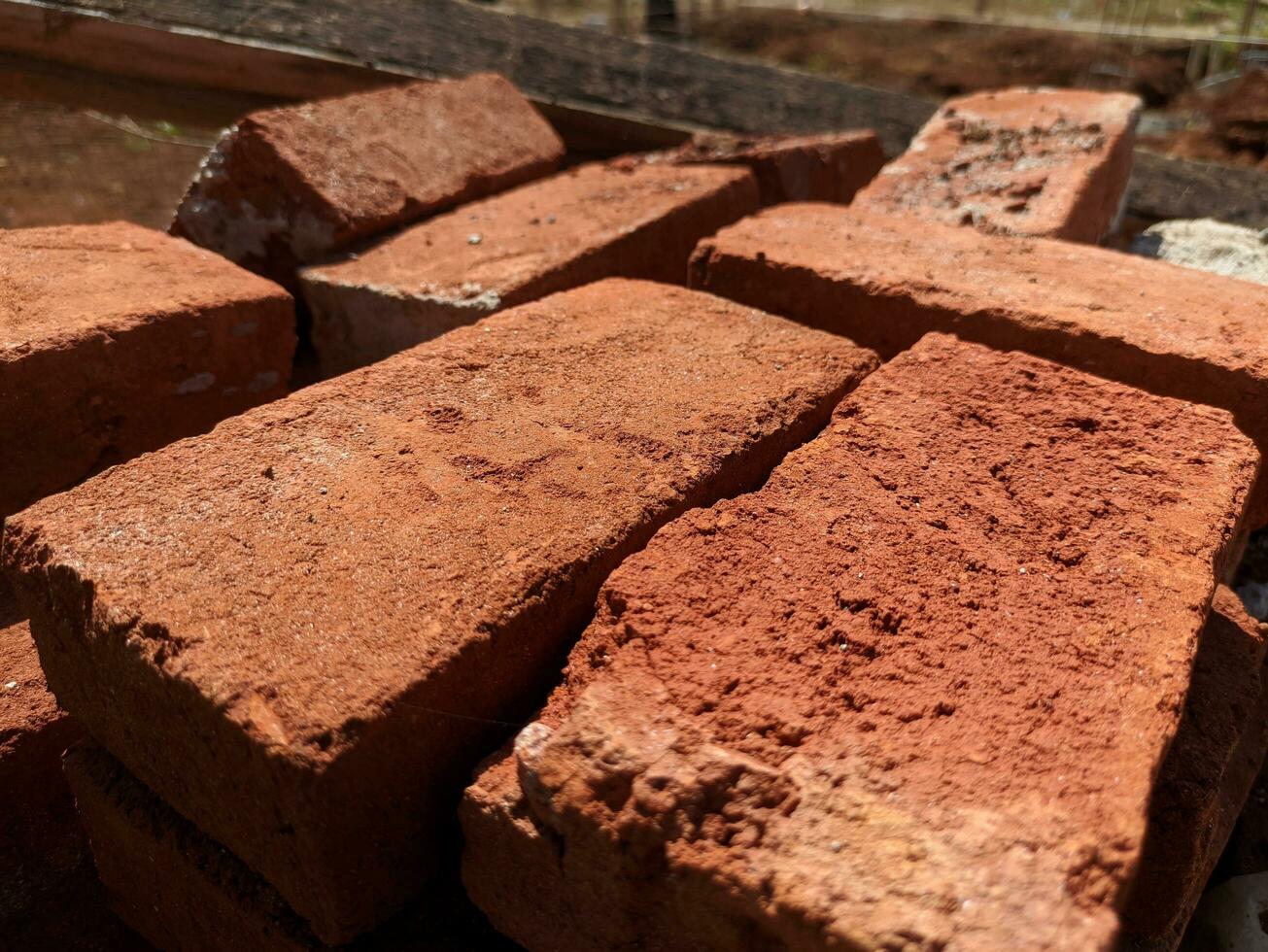 Close-up photo of a pile of bricks on the construction site. Construction of a new house. A pile of building materials, a stack of red bricks for construction is put together.