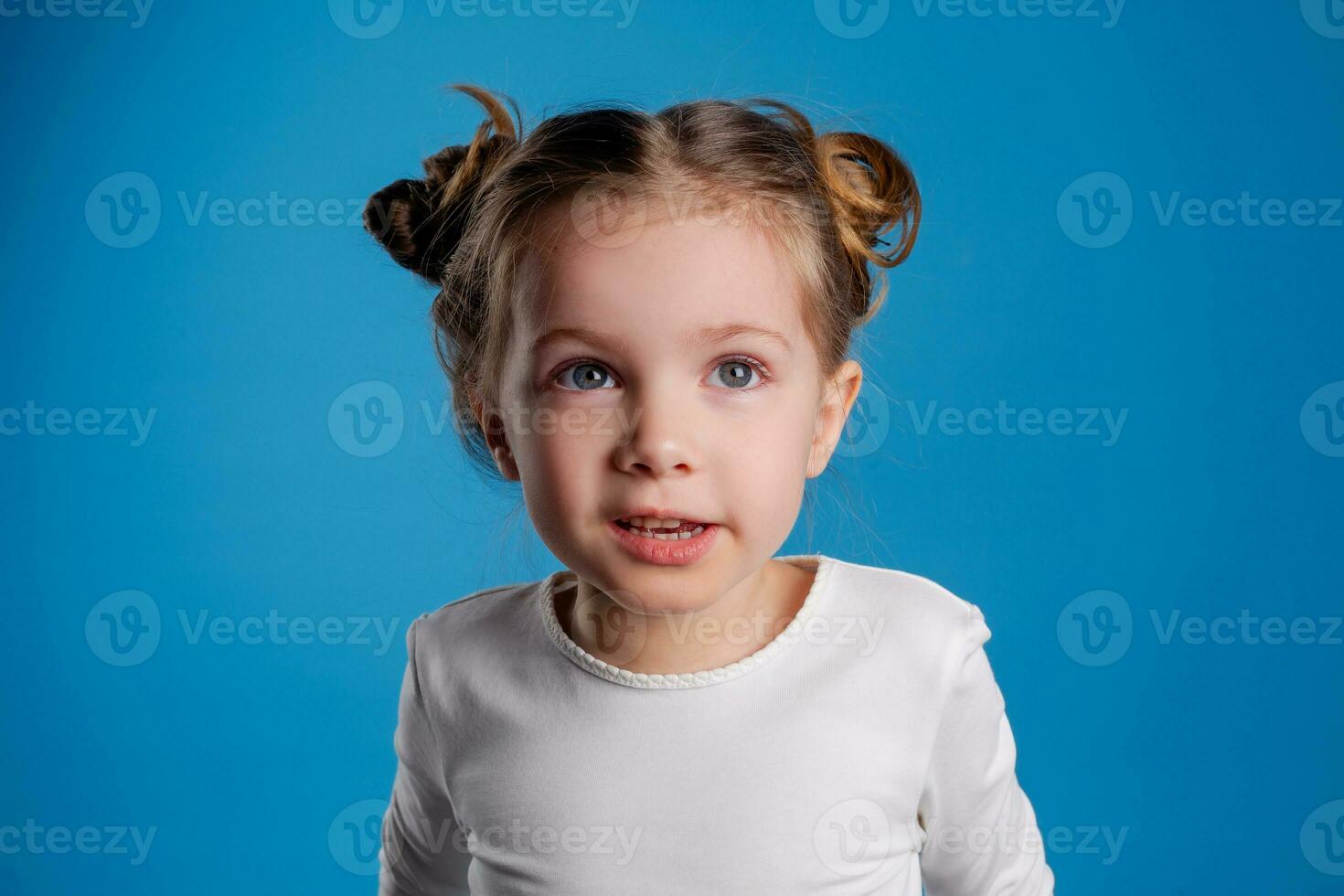 portrait of a small happy girl of Slavic appearance on a blue background. place for text photo