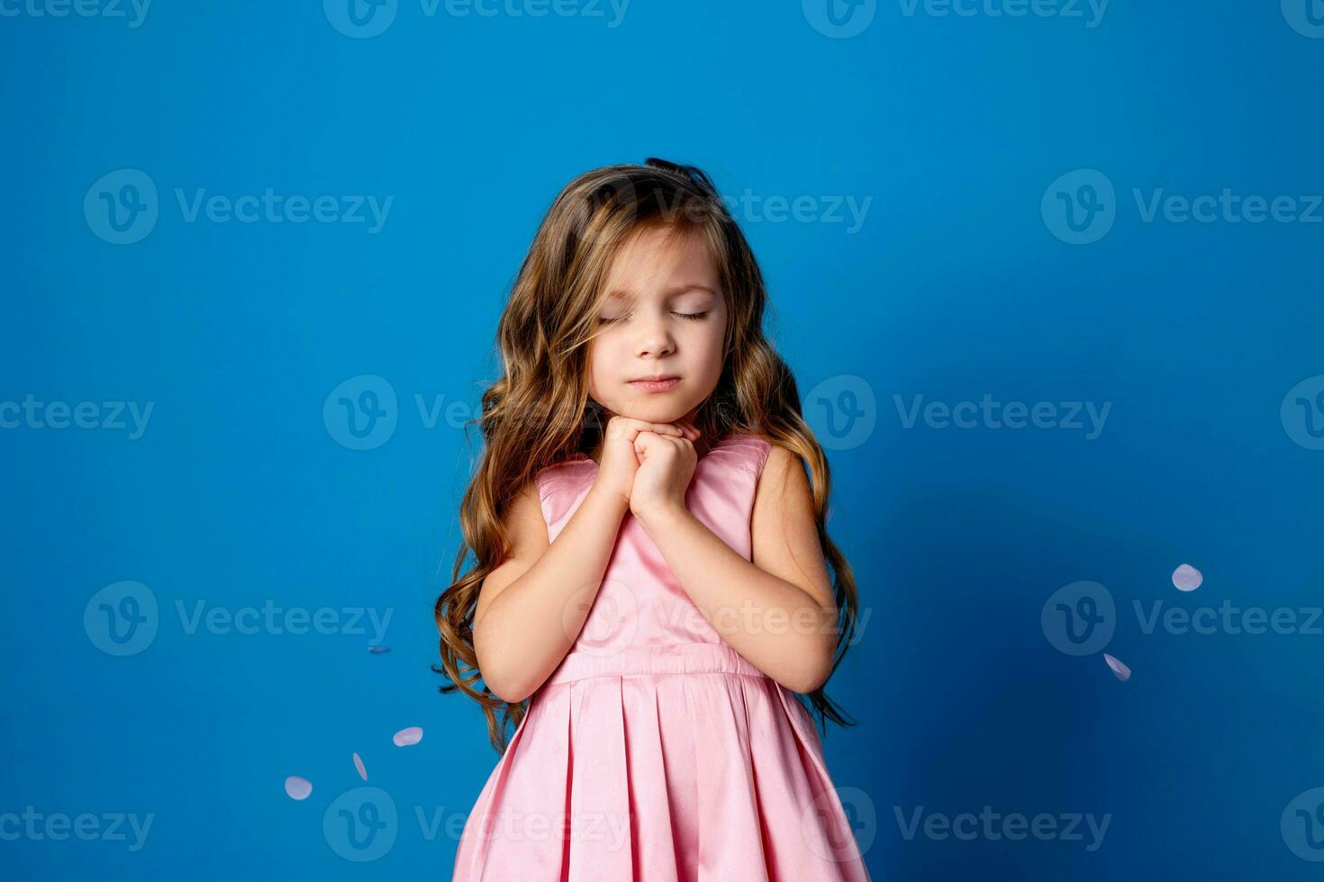 portrait of a small happy girl of Slavic appearance, making a wish for a holiday. place for text photo