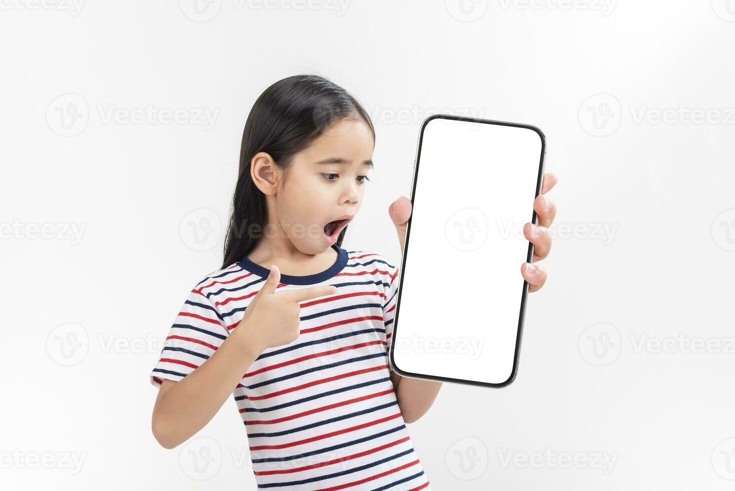 Asian little girl holding smartphone mockup of blank screen and smiling on white background. photo