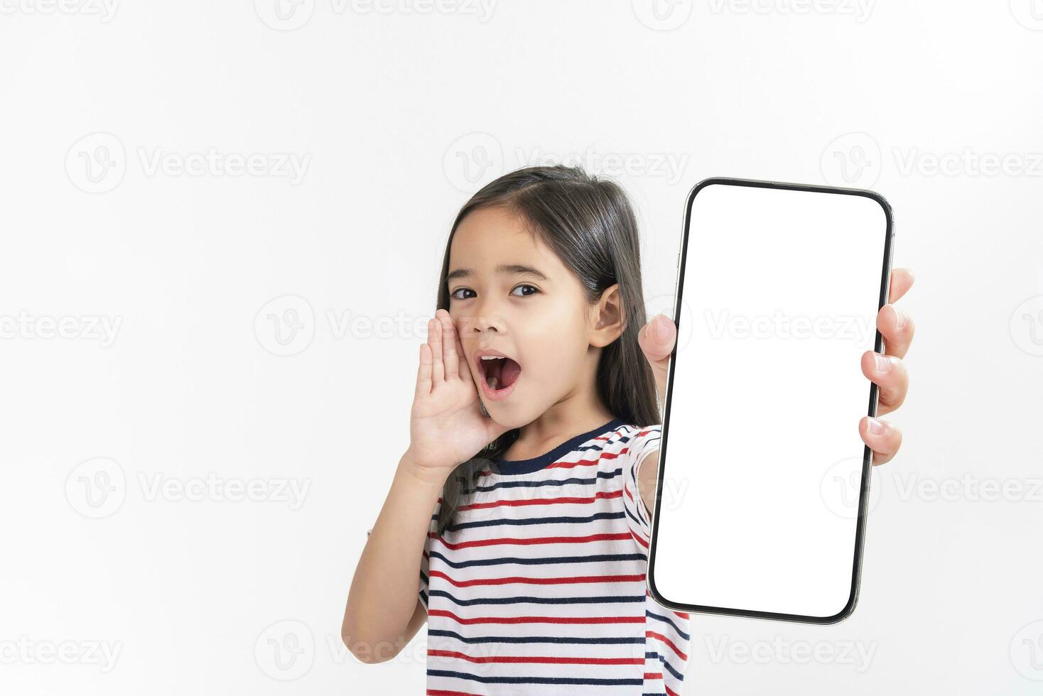 Asian little girl holding smartphone mockup of blank screen and smiling on white background. photo