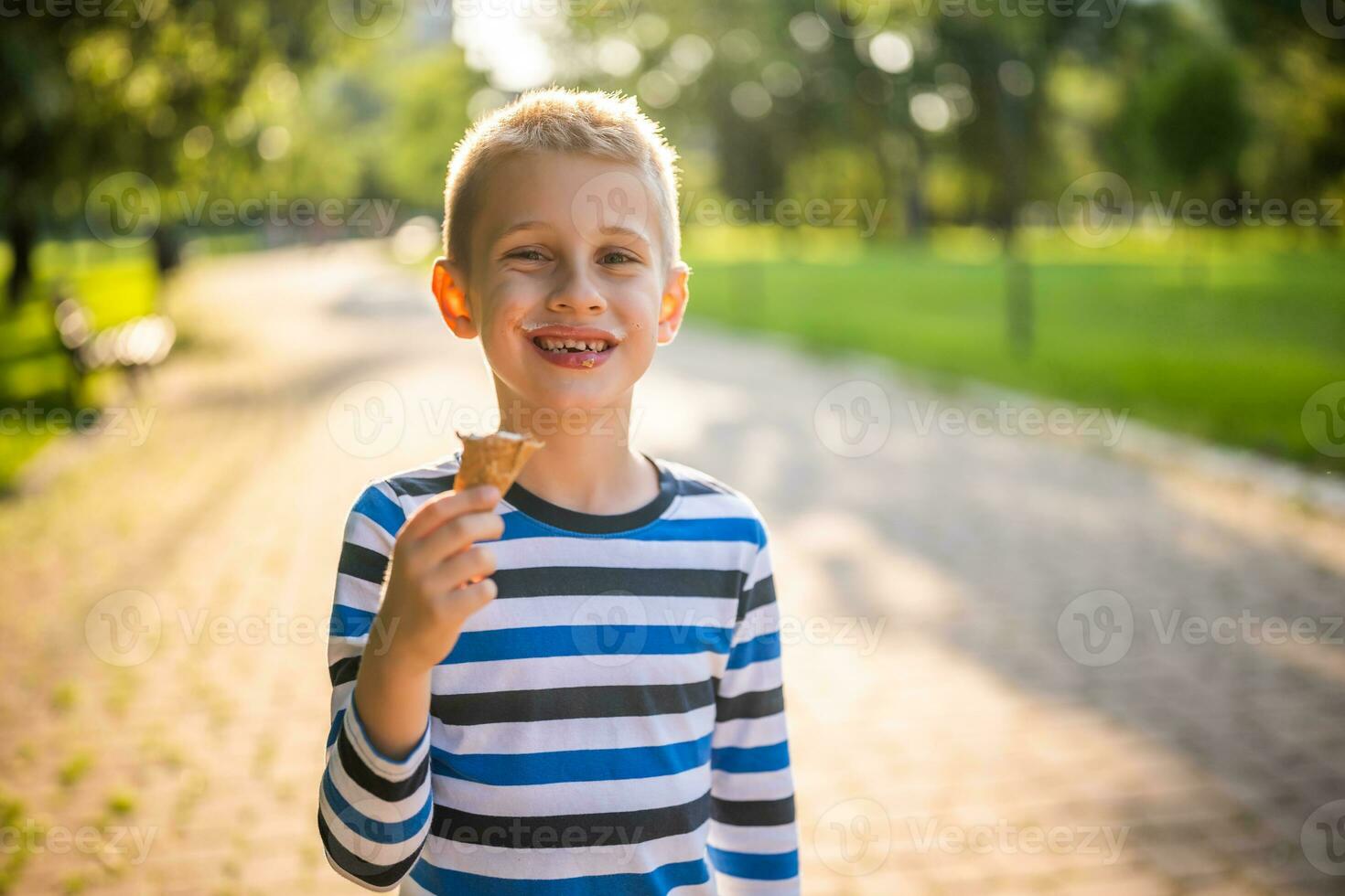 Little boy eating ice cream in the park photo