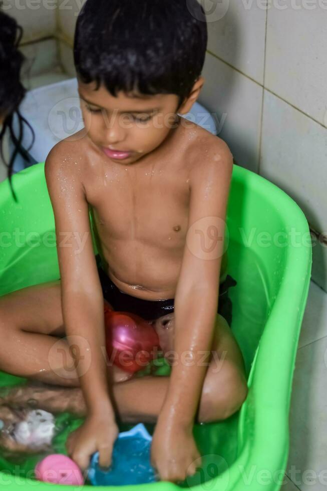 Cute Indian Boy having bath during the summer vacation season, Cute Asian child washing in a bathroom, Kid Bathing lifestyle concept photo