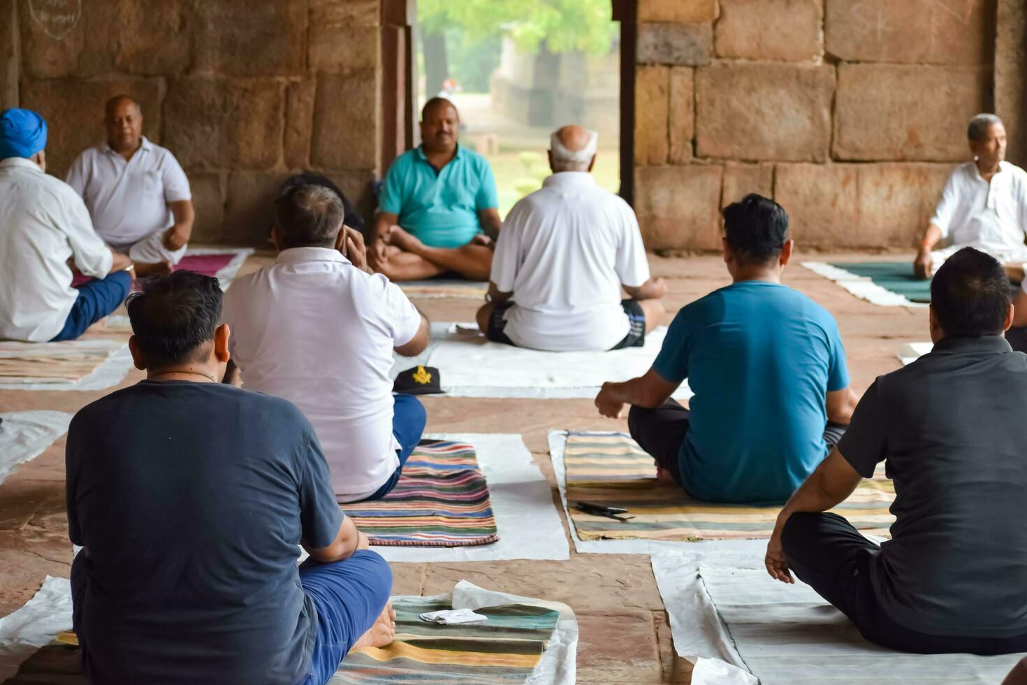 New Delhi, India, May 31 2023 - Group Yoga exercise class for people of different age in Lodhi Garden, International Yoga Day, Big group of adults attending a yoga class in park photo
