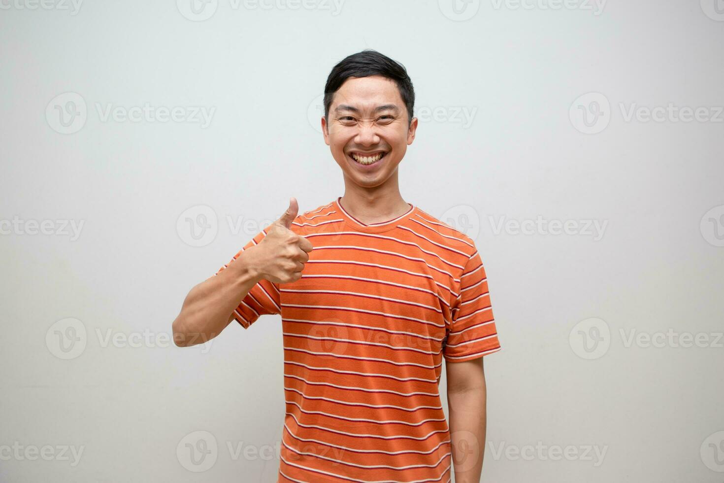 alegre asiático hombre naranja camisa espectáculo pulgar arriba con contento sonrisa con exitoso aislado foto