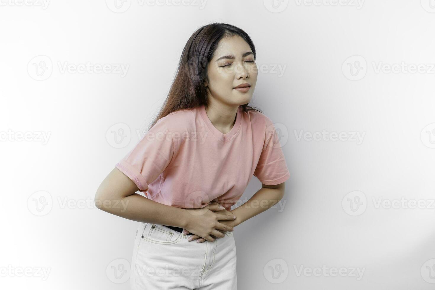 un asiático mujer es hambriento o teniendo menstruación o estómago dolor y conmovedor su barriga foto