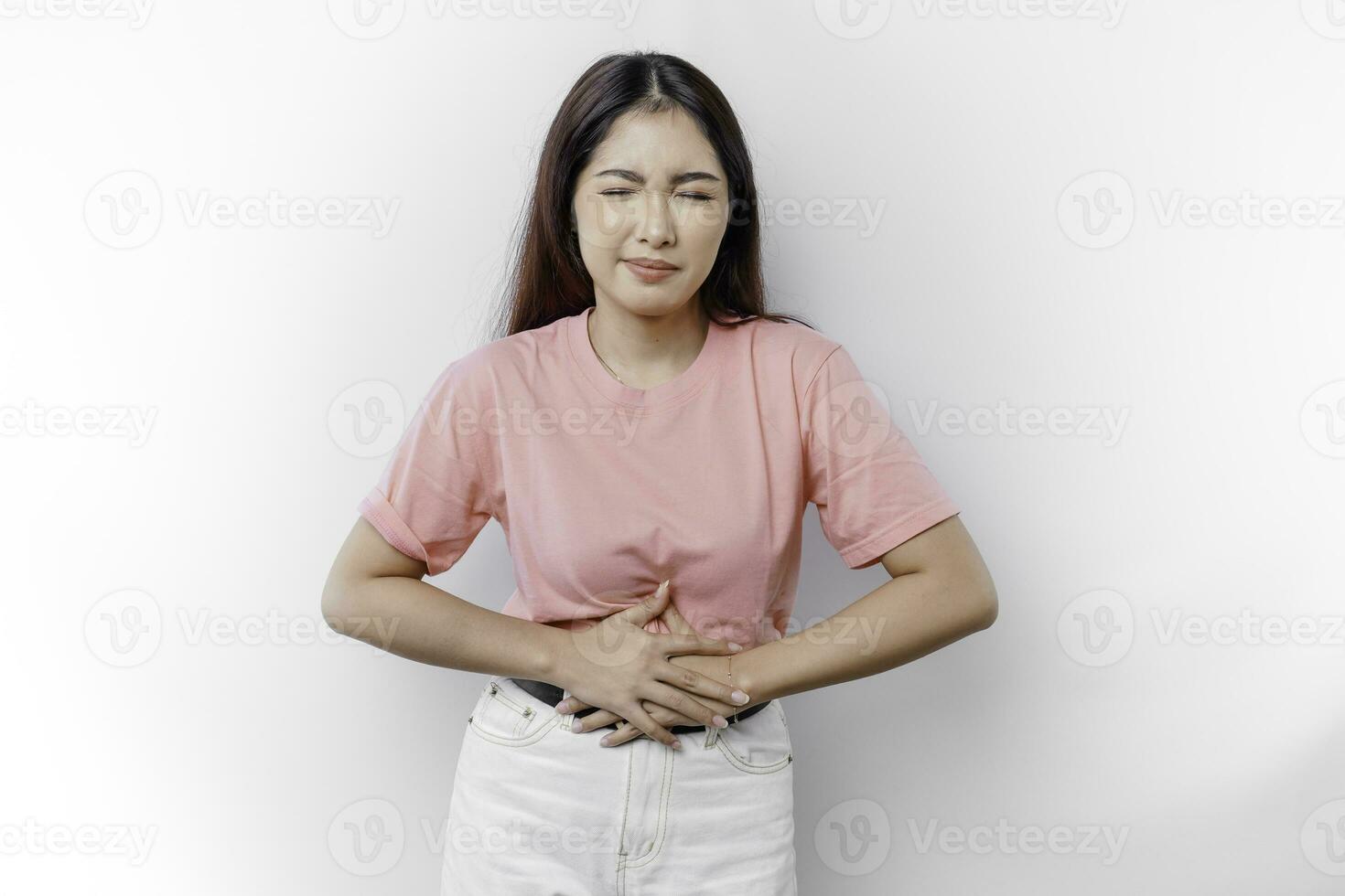 un asiático mujer es hambriento o teniendo menstruación o estómago dolor y conmovedor su barriga foto