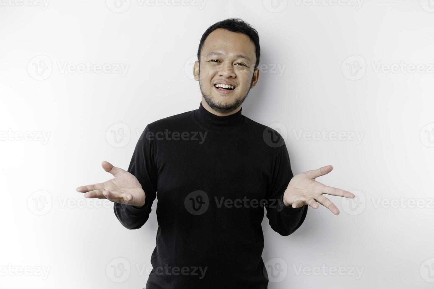 Young Asian man wearing black t-shirt presenting an idea while looking smiling on isolated white background photo