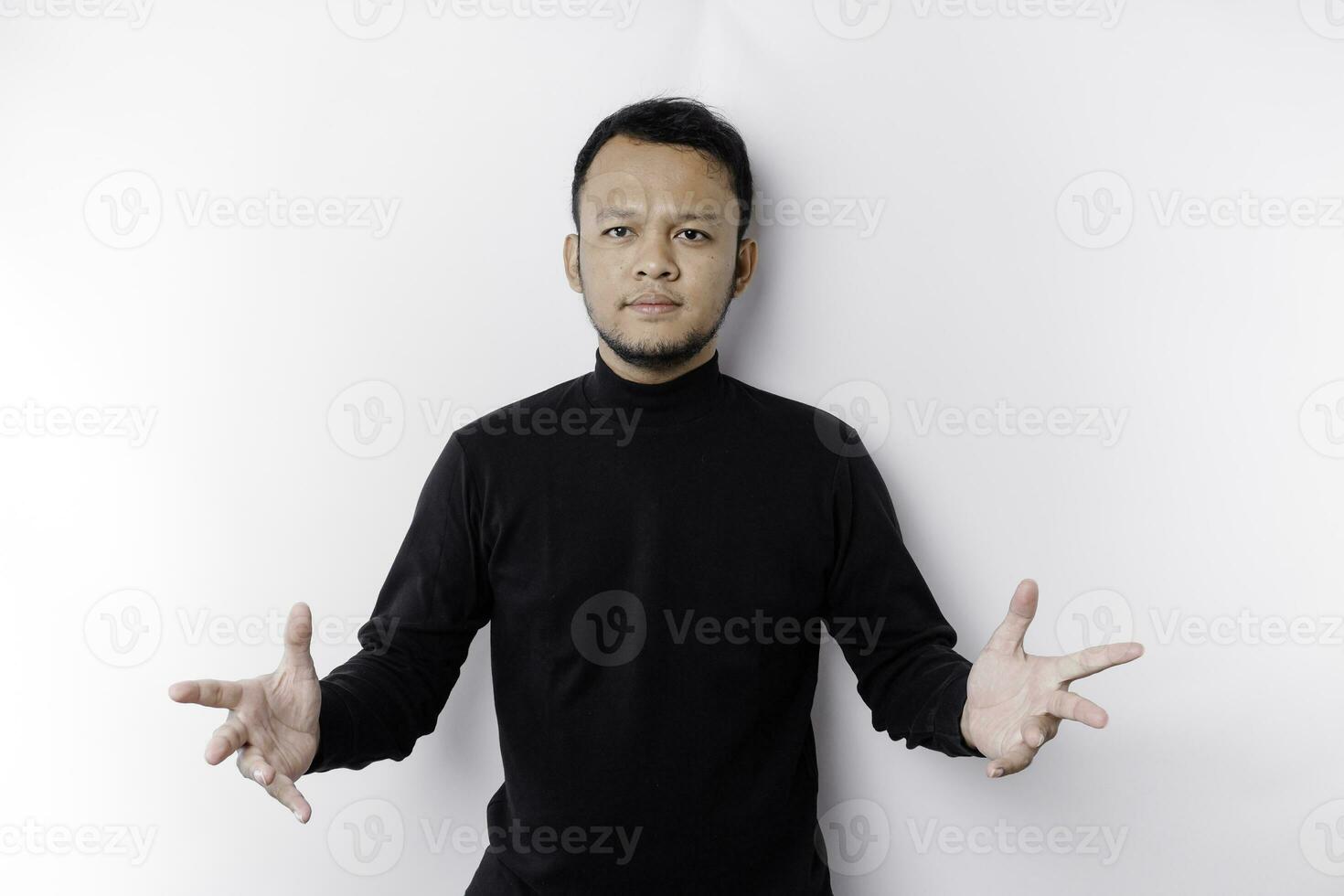 Young Asian man wearing black t-shirt presenting an idea while looking smiling on isolated white background photo