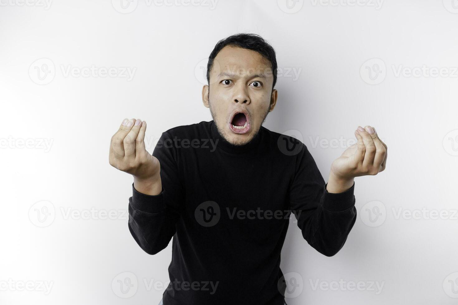 The angry and mad face of Asian man in black shirt isolated white background. photo