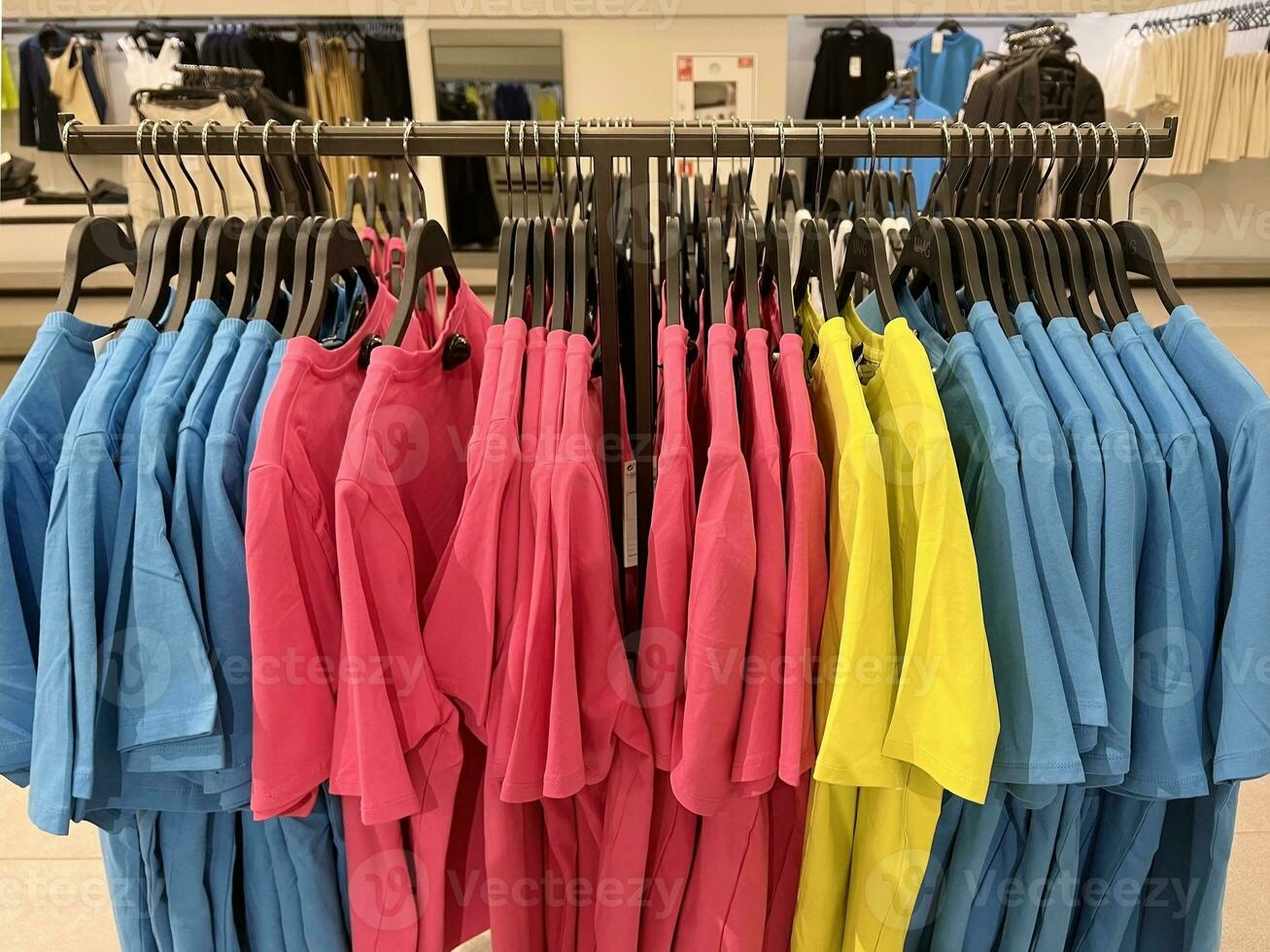 Clothes hang on a hanger in the store. Style and wardrobe. Bright clothes photo