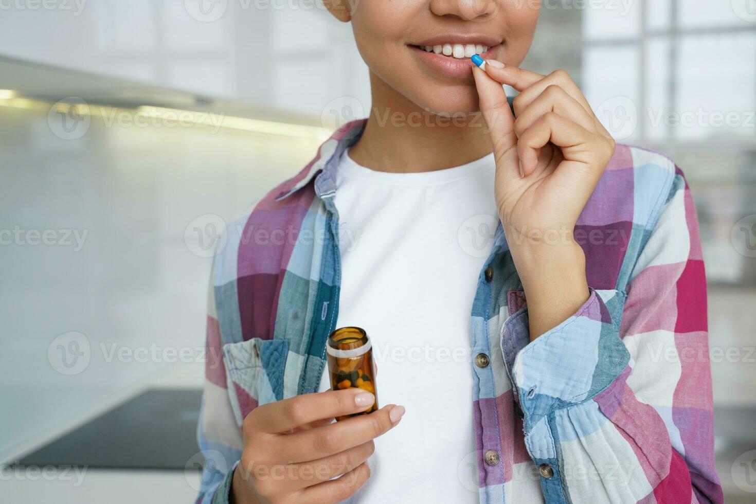 Young girl taking vitamins pills, dietary supplement for female skin