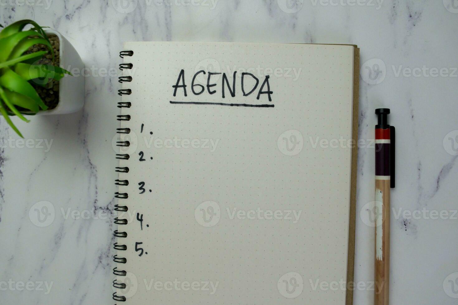Concept of Agenda write on a book isolated on Wooden Table. photo