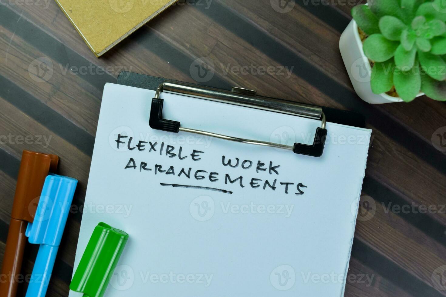 Concept of Flexible work Arrangements write on paperwork isolated on Wooden Table. photo