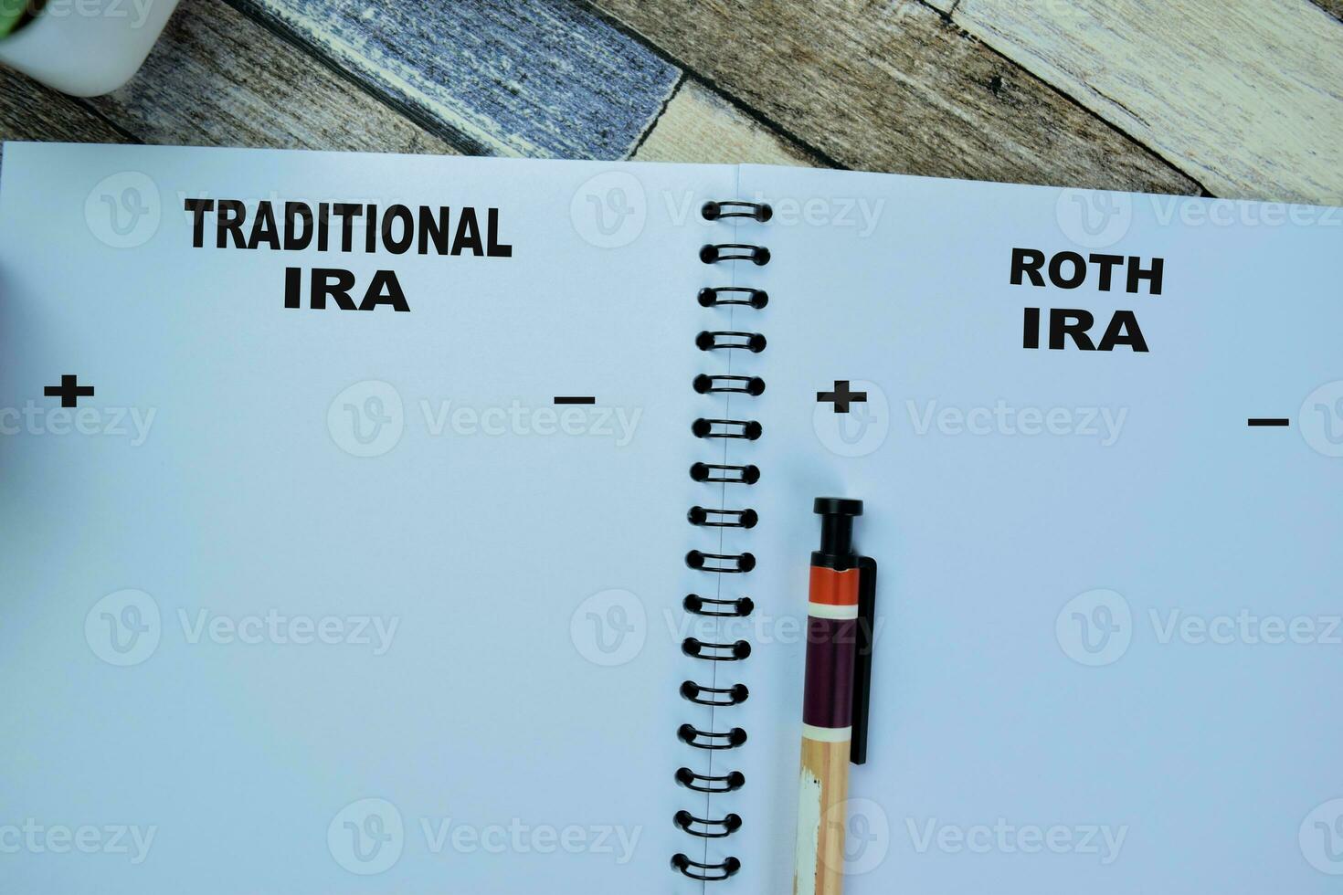 Concept of Traditional IRA and Roth IRA write on book isolated on Wooden Table. photo