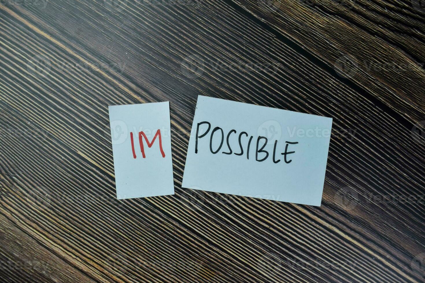 Concept of Impossible to be possible write on sticky notes isolated on Wooden Table. photo