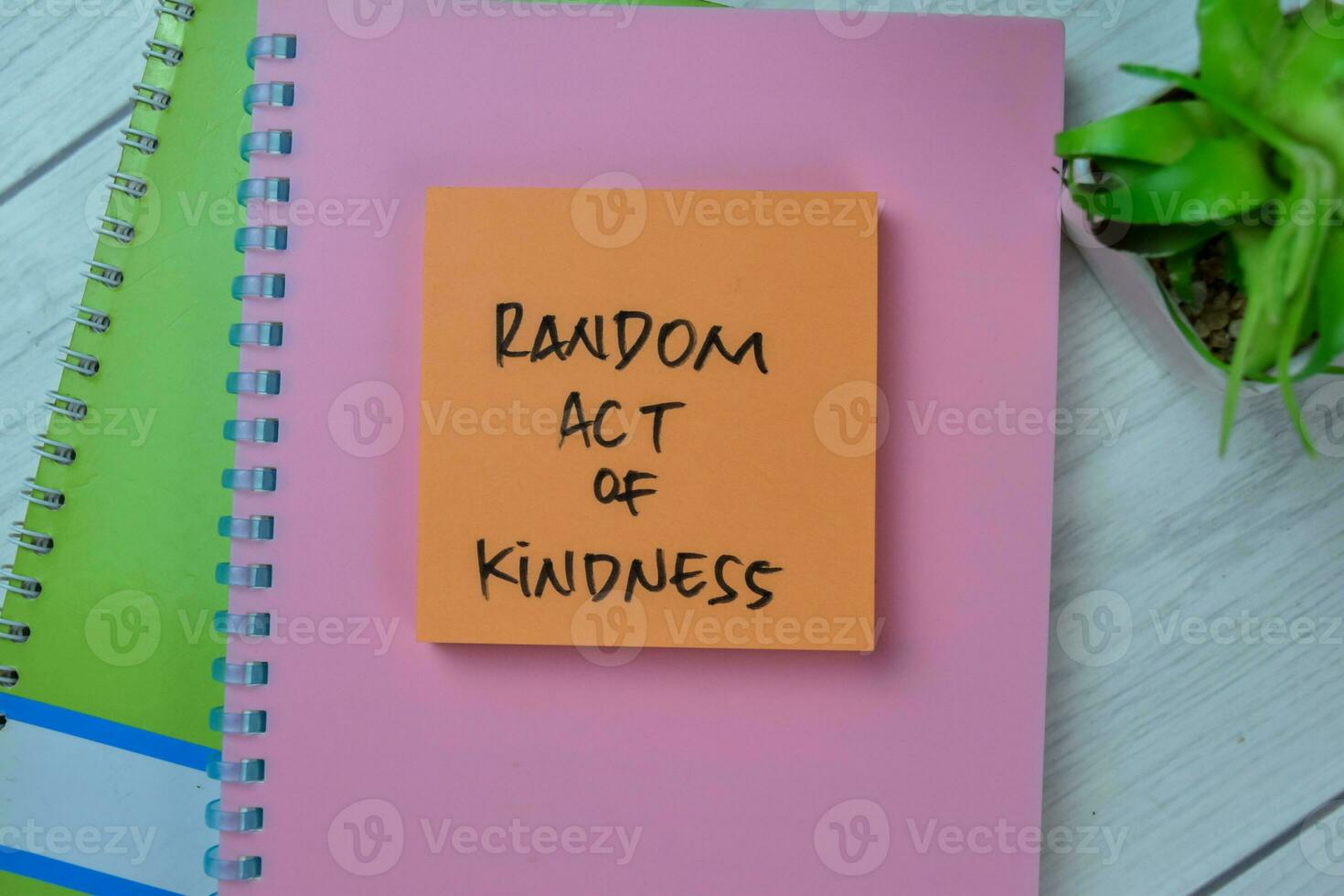 Concept of Random Act of Kindness write on sticky notes isolated on Wooden Table. photo