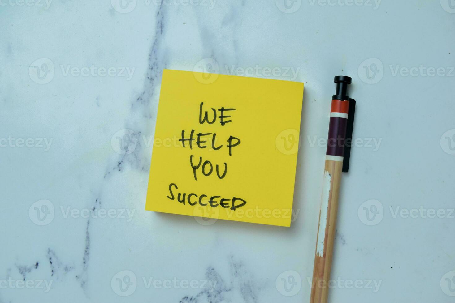 Concept of We Help You Succeed write on sticky notes isolated on Wooden Table. photo