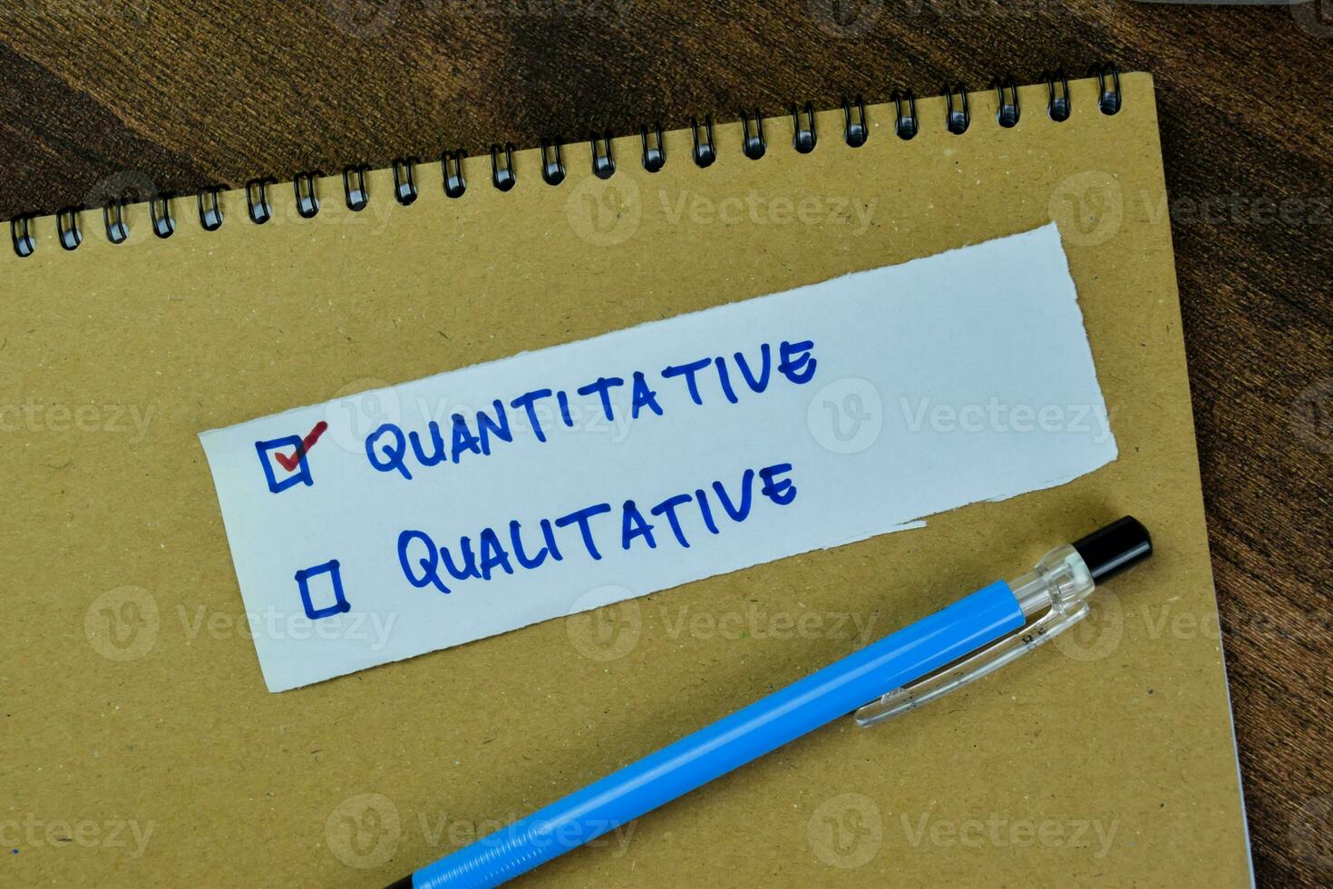 Concept of Quantitative and Qualitative write on sticky notes isolated on Wooden Table. photo
