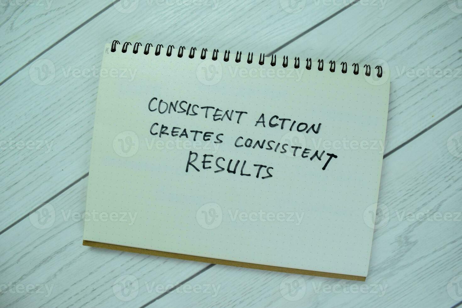 Concept of Consisten Action Creates Consistent Results write on book isolated on Wooden Table. photo