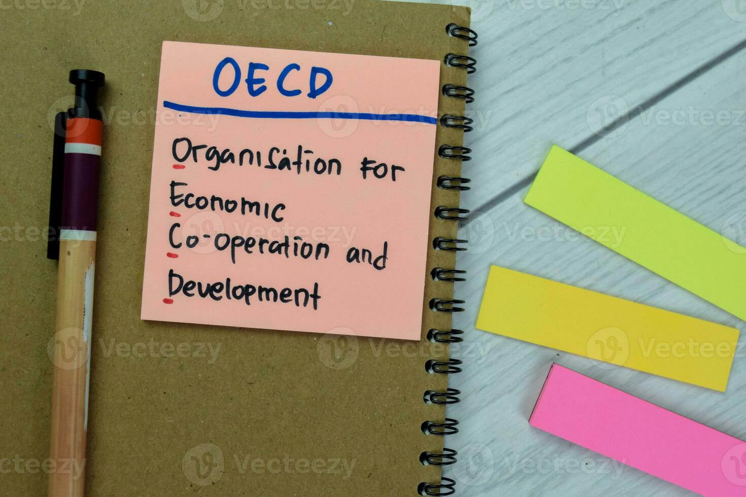 Concept of OECD - Organisation for Economic Co-operation and Development write on sticky notes isolated on Wooden Table. photo