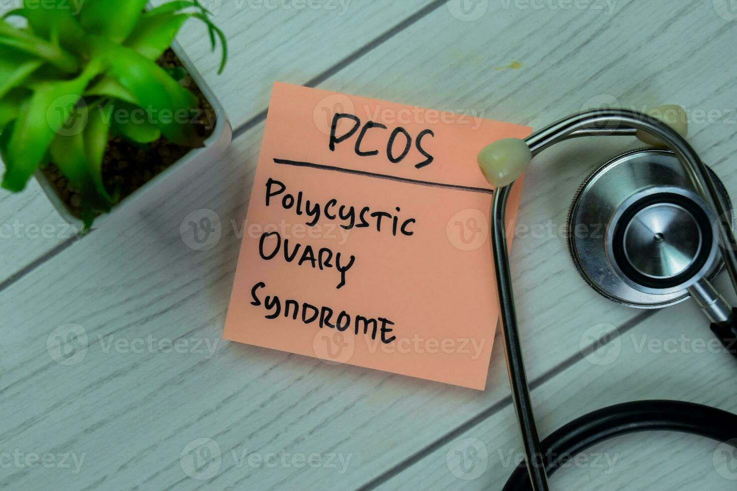 Concept of POCS Polycystic Ovary Syndrome write on sticky notes with stethoscope isolated on Wooden Table. photo