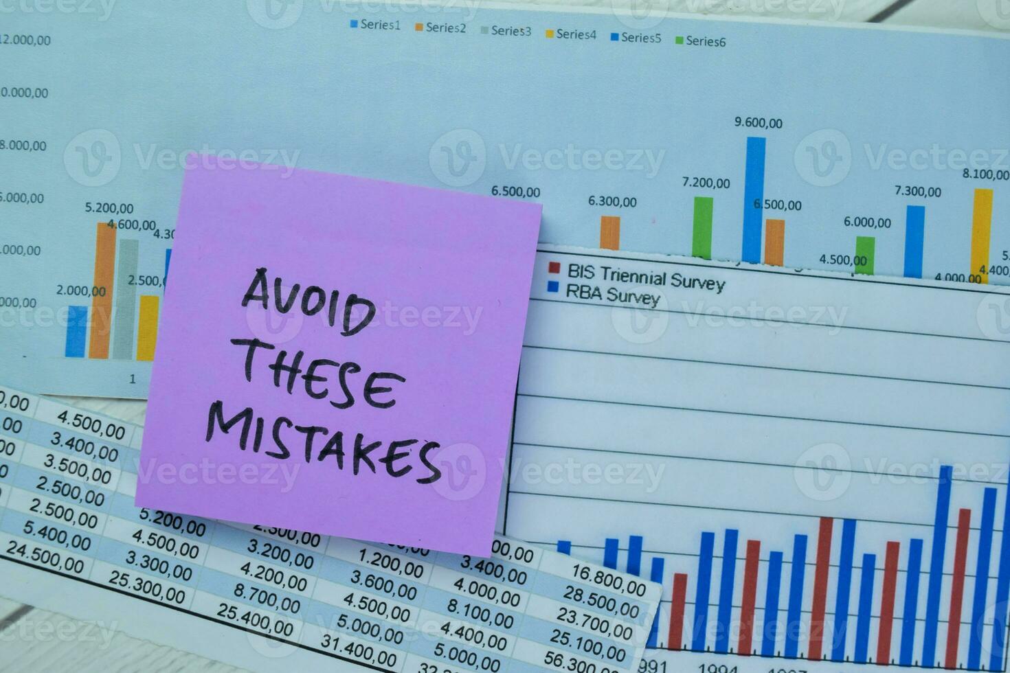 Concept of Avoid These Mistakes write on sticky notes isolated on Wooden Table. photo