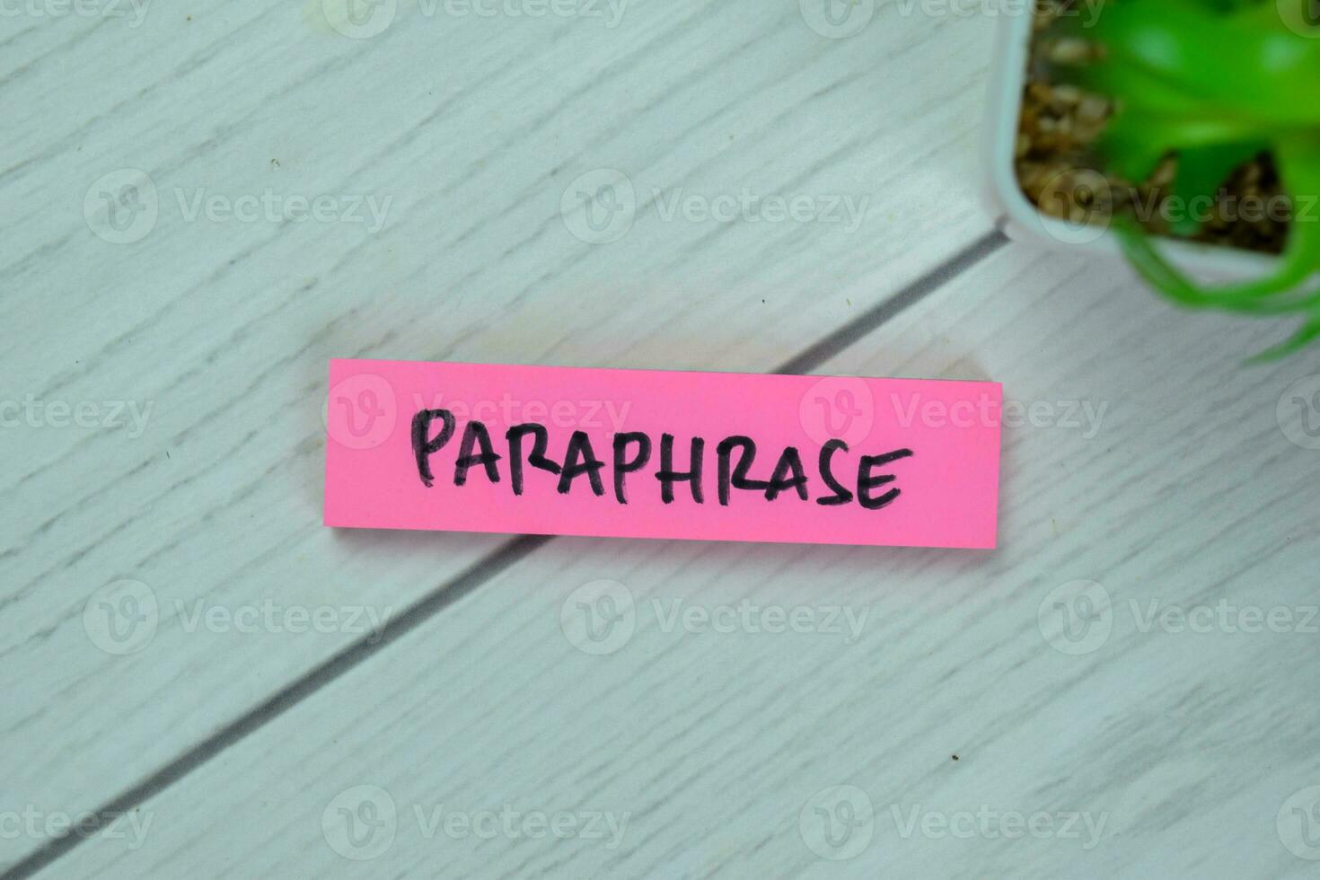 Concept of Paraphrase write on sticky notes isolated on Wooden Table. photo