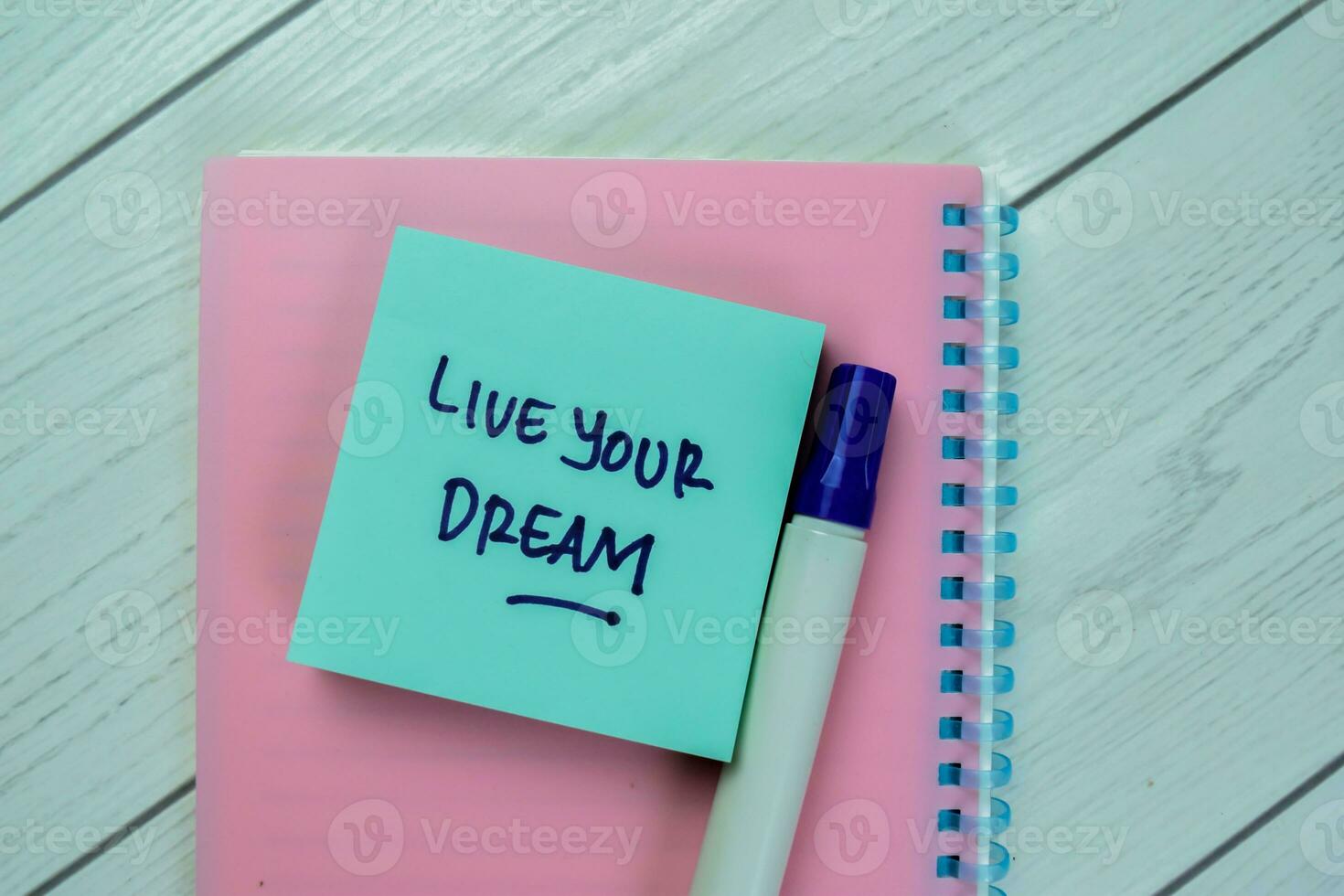 Concept of Live Your Dream write on sticky notes isolated on Wooden Table. photo
