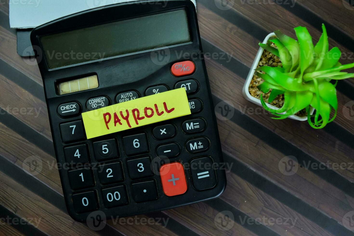 Concept of Payroll write on sticky notes with calculator isolated on Wooden Table. photo