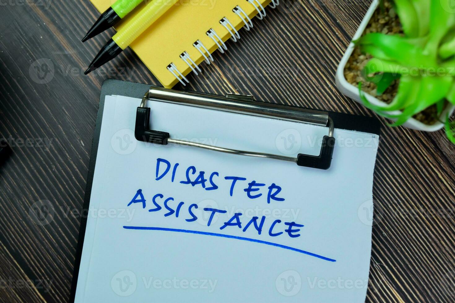 Concept of Disaster Assistance write on paperwork isolated on Wooden Table. photo