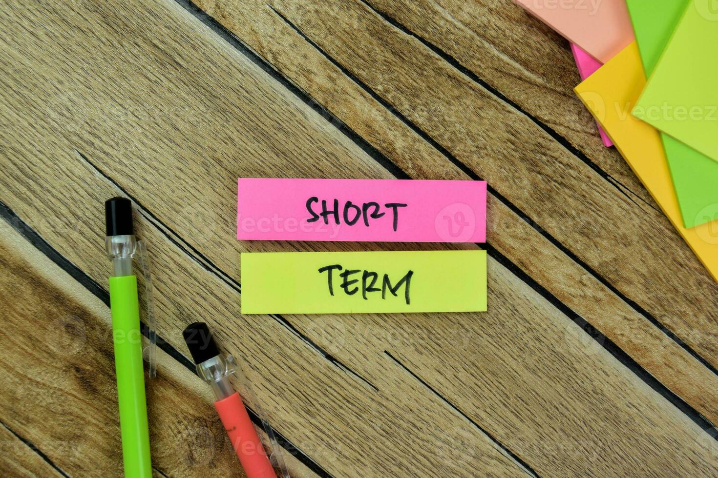 Concept of Short Term write on sticky notes isolated on Wooden Table. photo