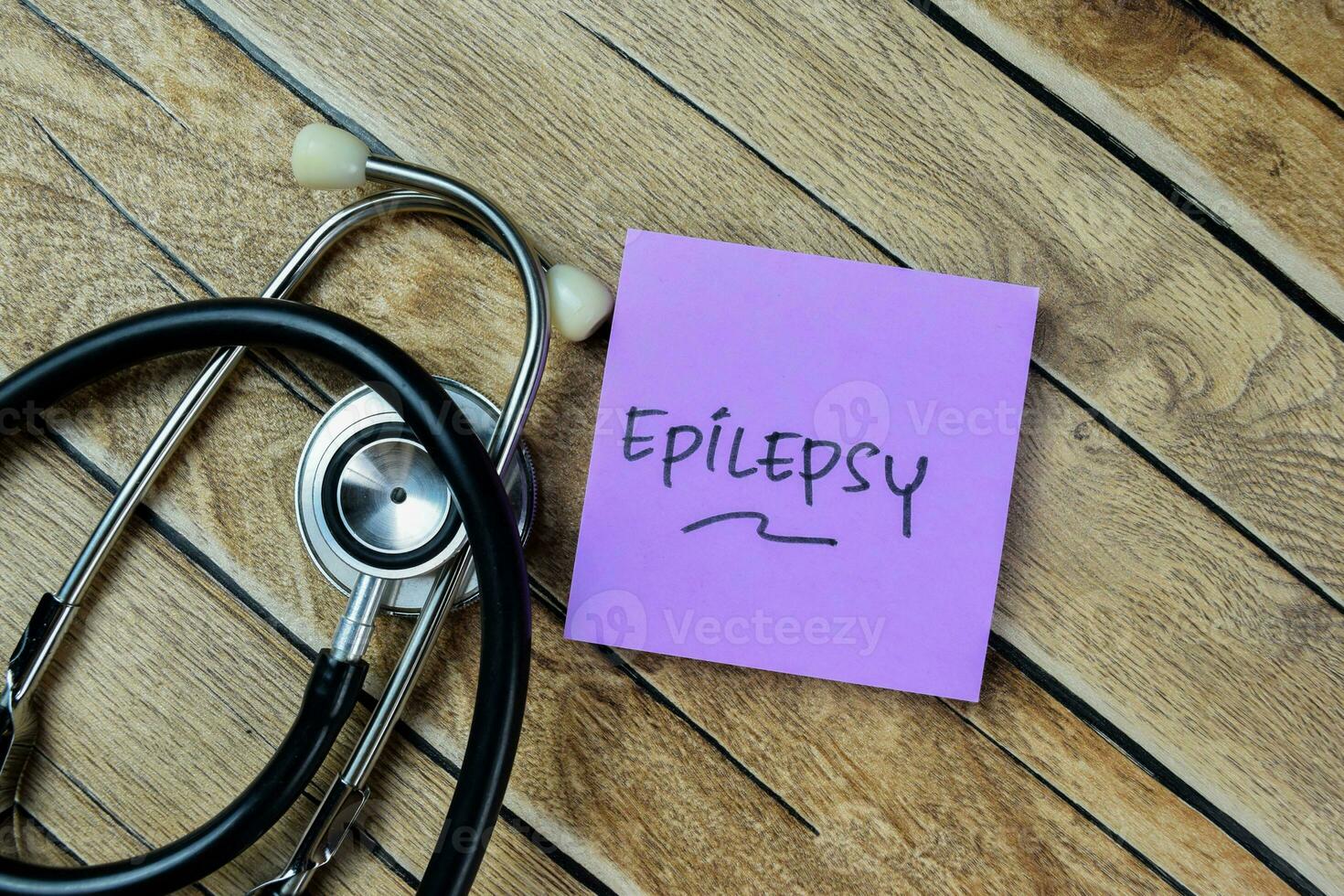 Concept of Epilepsy write on sticky notes with stethoscope isolated on Wooden Table. photo