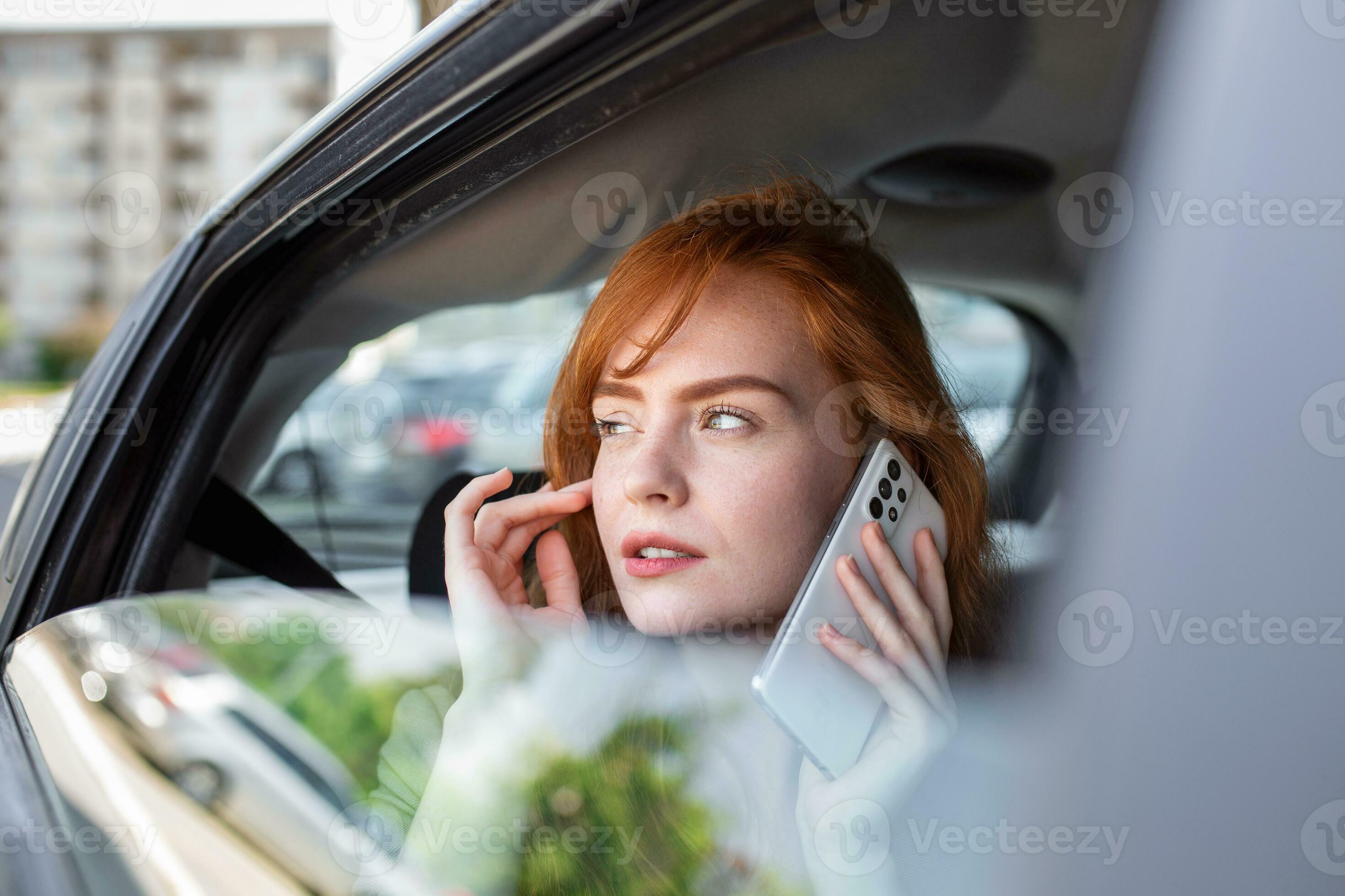 Young girl uses a mobile phone in the car. Technology cell phone