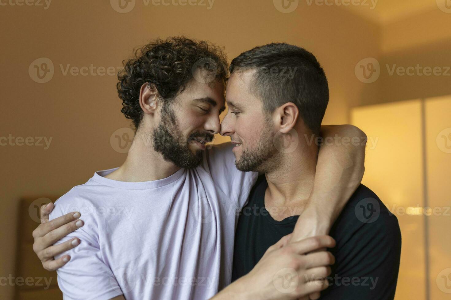 Two young man lgbtq gay couple dating in love hugging enjoying intimate tender sensual moment together kissing with eyes closed photo