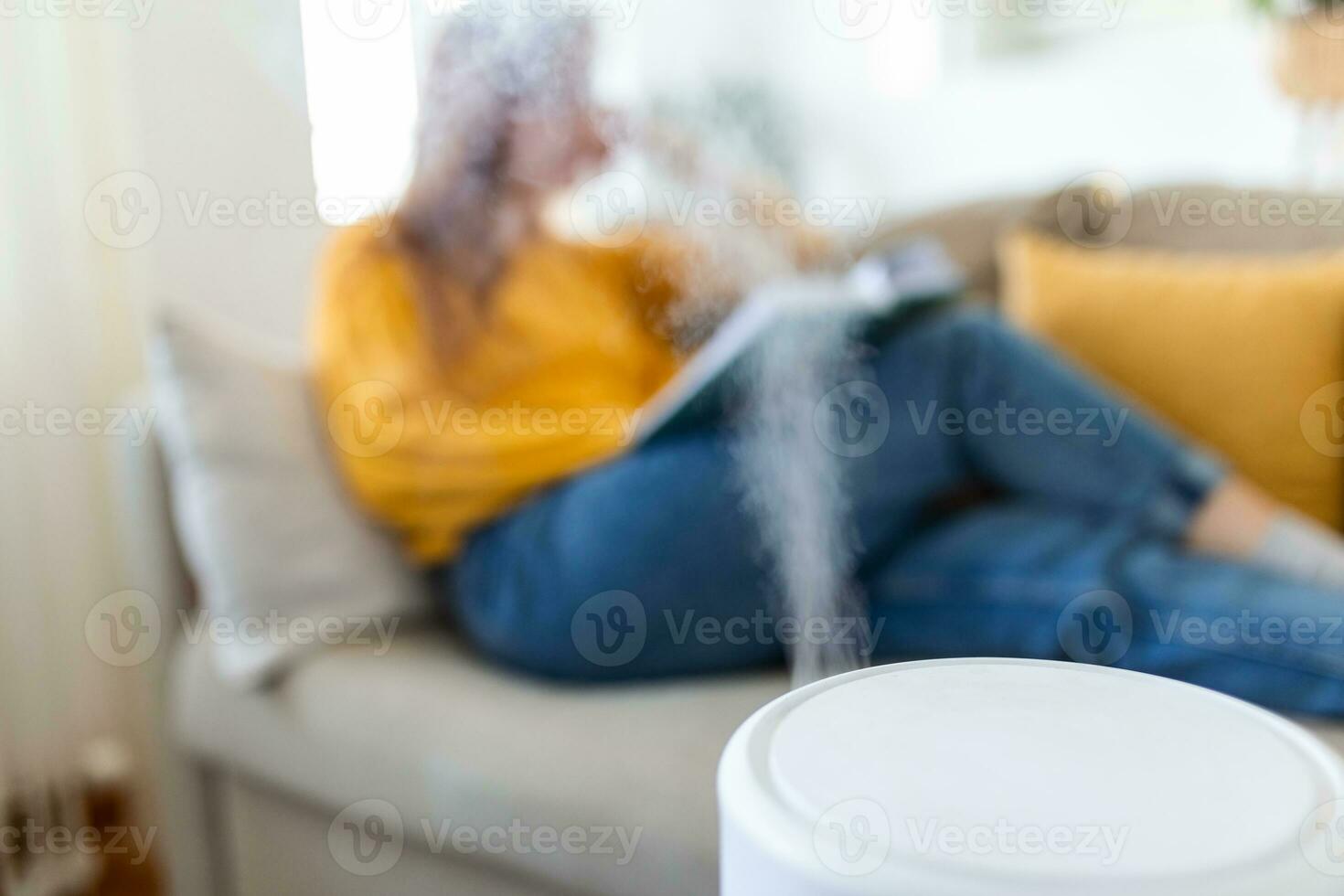 Air purifier in cozy white Living room for filter and cleaning removing dust PM2.5 HEPA at home with woman reading a book on sofa,for fresh air and healthy life,Air Pollution Concept photo