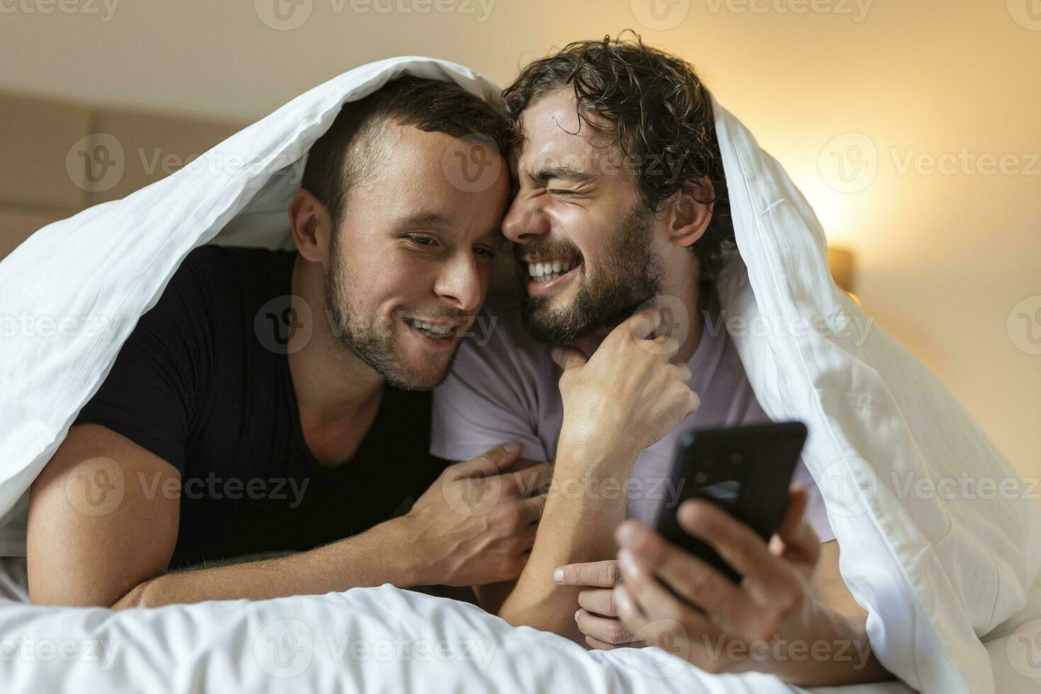 Happy gay couple having tender moments in bedroom - Homosexual love relationship and gender equality concept photo