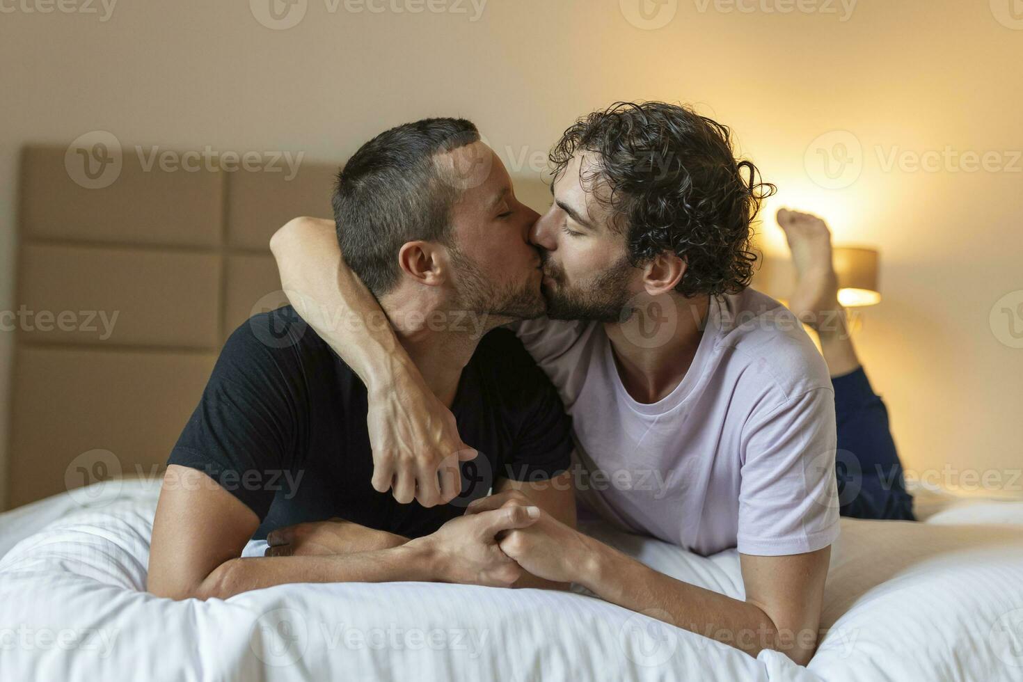 Two young man lgbtq gay couple dating in love hugging enjoying intimate tender sensual moment together kissing with eyes closed photo
