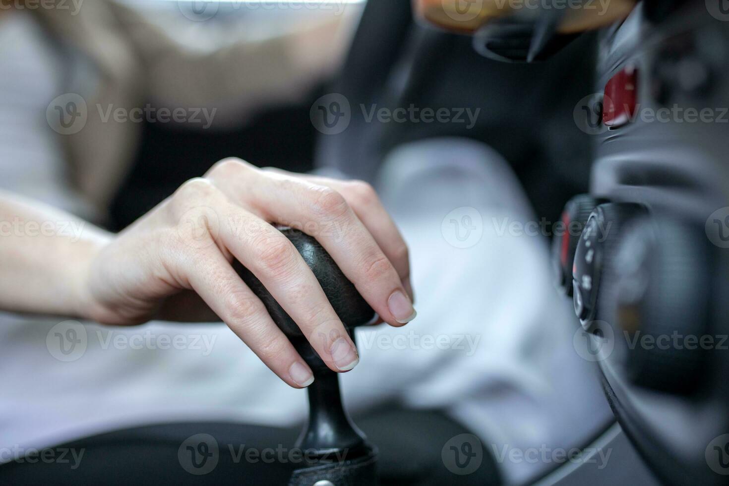 Cropped shot of an unrecognizable woman's hand on his gearstick while driving photo