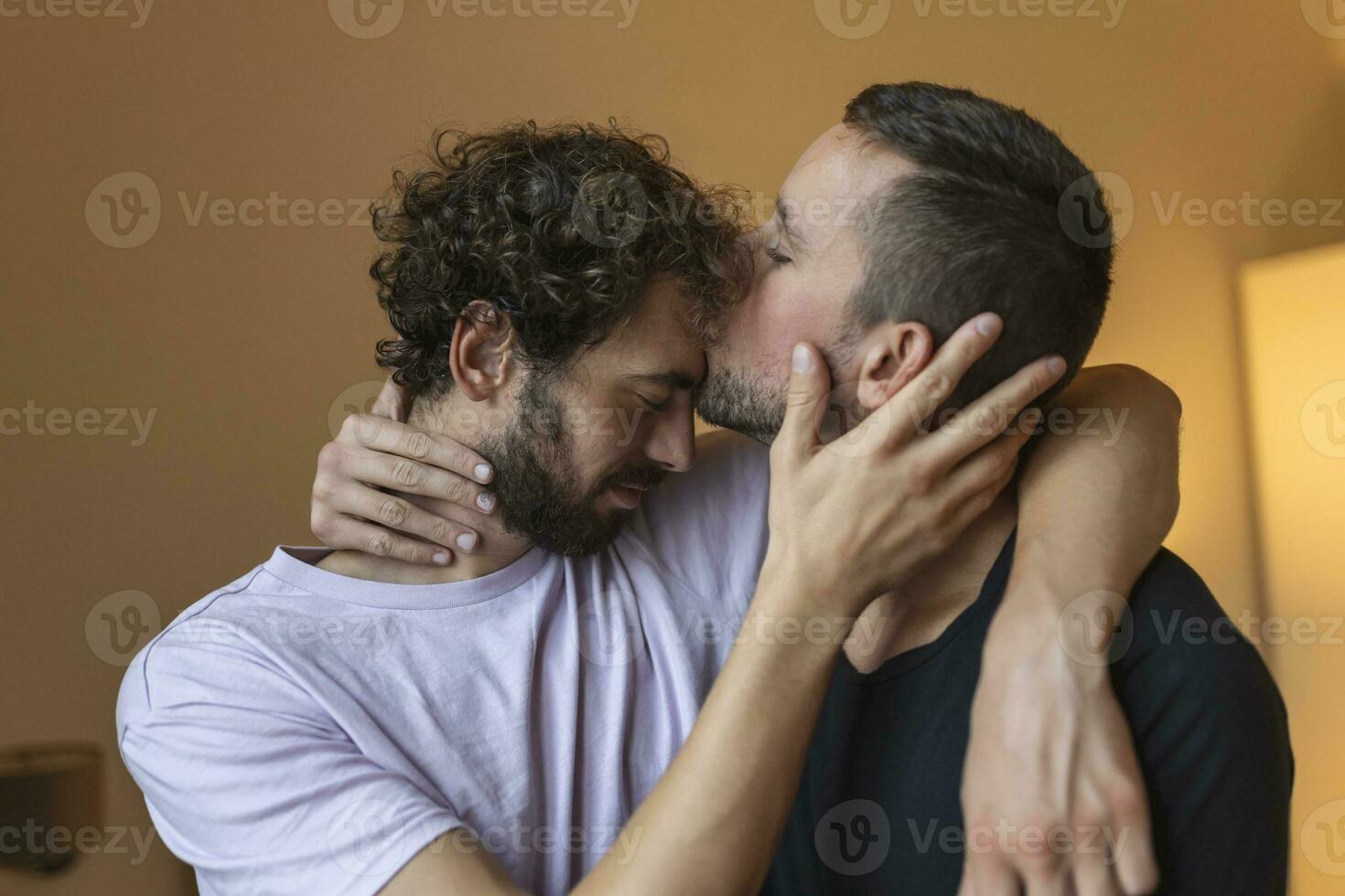 Two young man lgbtq gay couple dating in love hugging enjoying intimate tender sensual moment together kissing with eyes closed photo