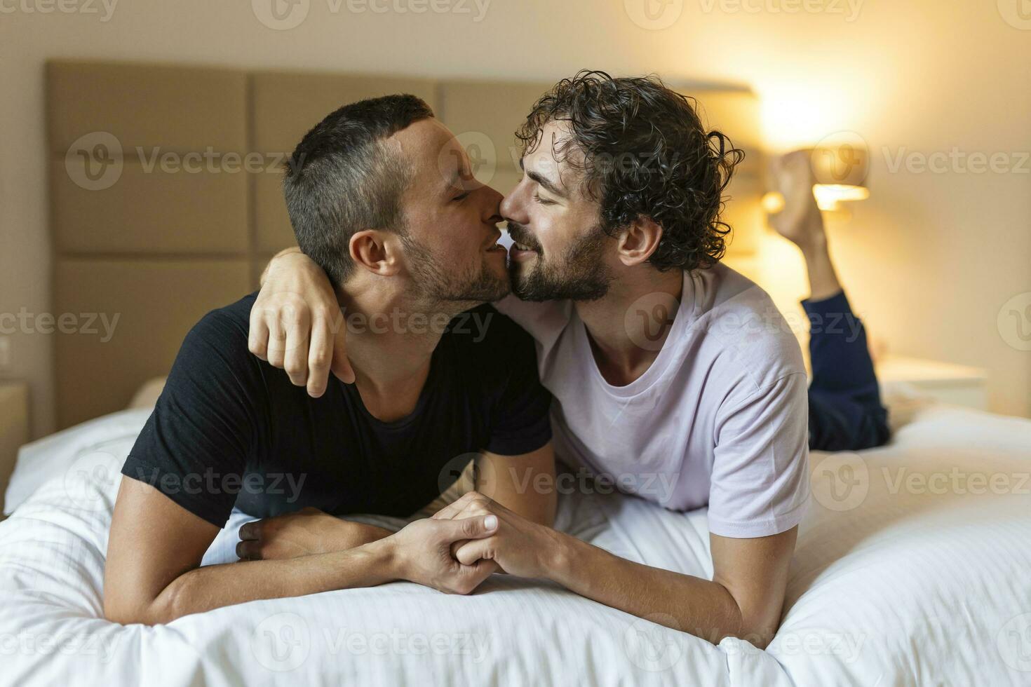 Two young man lgbtq gay couple dating in love hugging enjoying intimate tender sensual moment together kissing with eyes closed photo